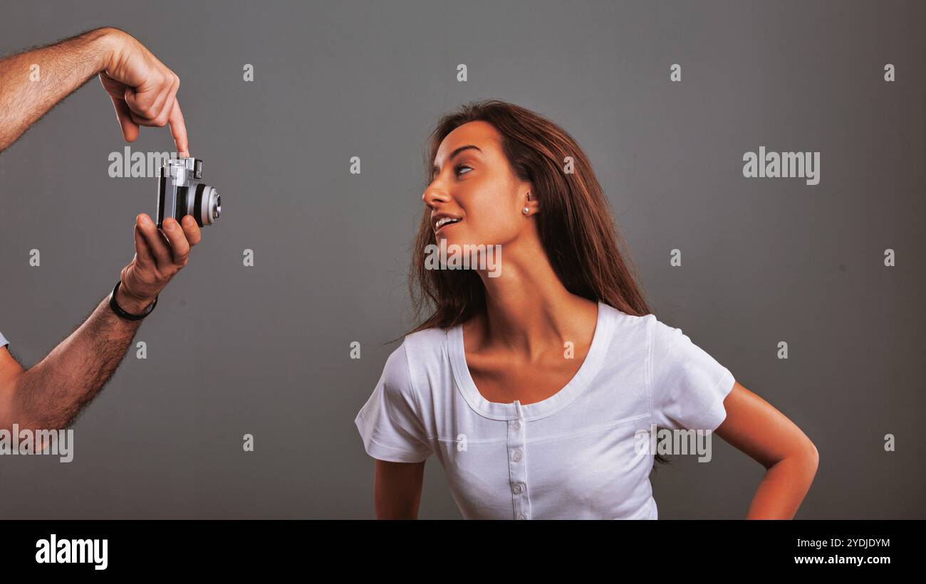 Fotografin zeigt einer jungen Frau, wie man eine Vintage-Kamera benutzt, unterrichtet ihre fotografischen Fähigkeiten und teilt ihr Wissen im Studio Stockfoto