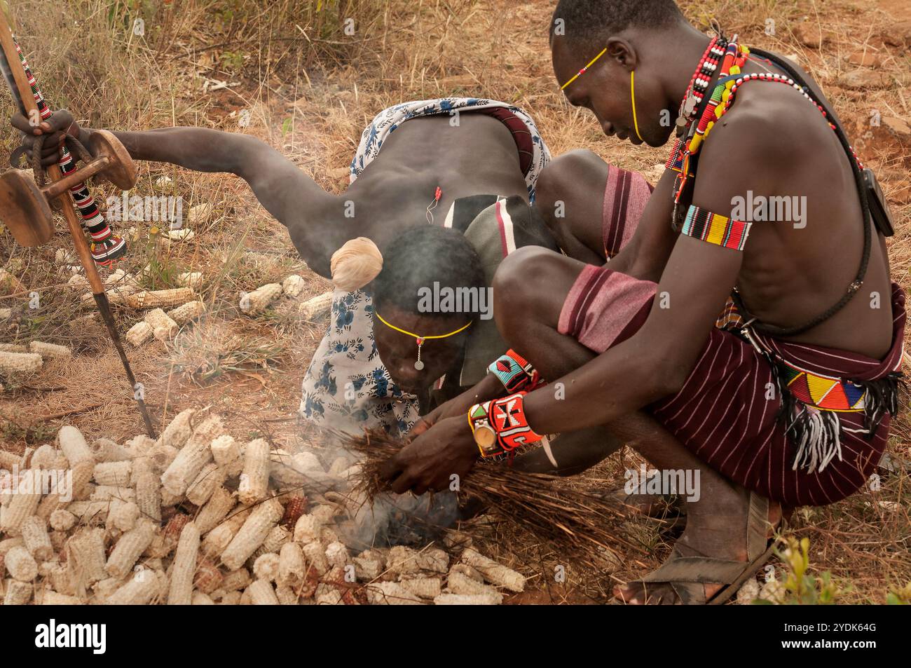 Zwei Pokot-Stammesleute zünden ein Feuer mit traditionellen Methoden in einem Dorf im Norden Kenias, Afrika. Stockfoto