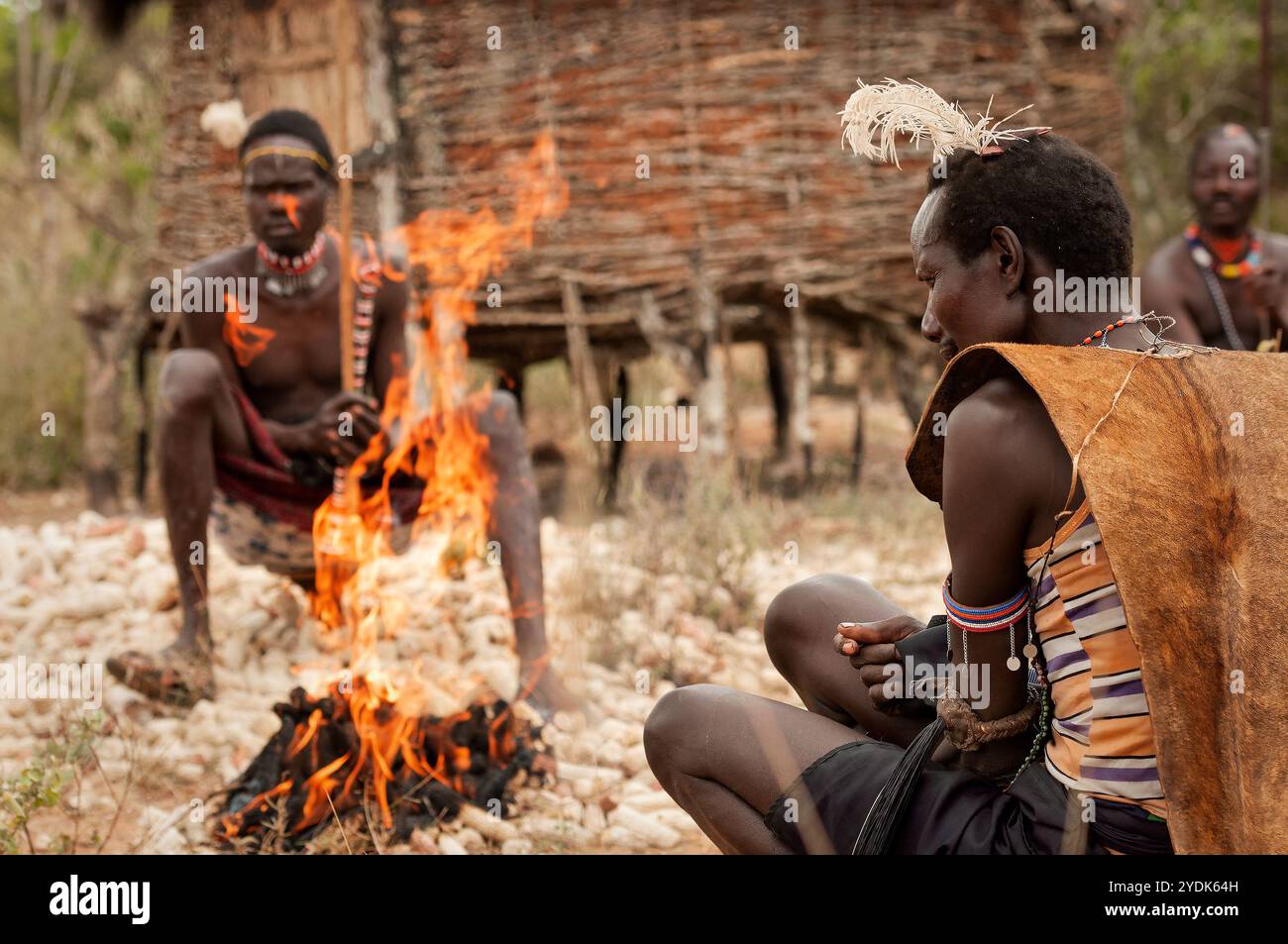 Pokot-Stammesleute vor einem Feuer in einem Dorf in Nordkenia, Afrika. Stockfoto