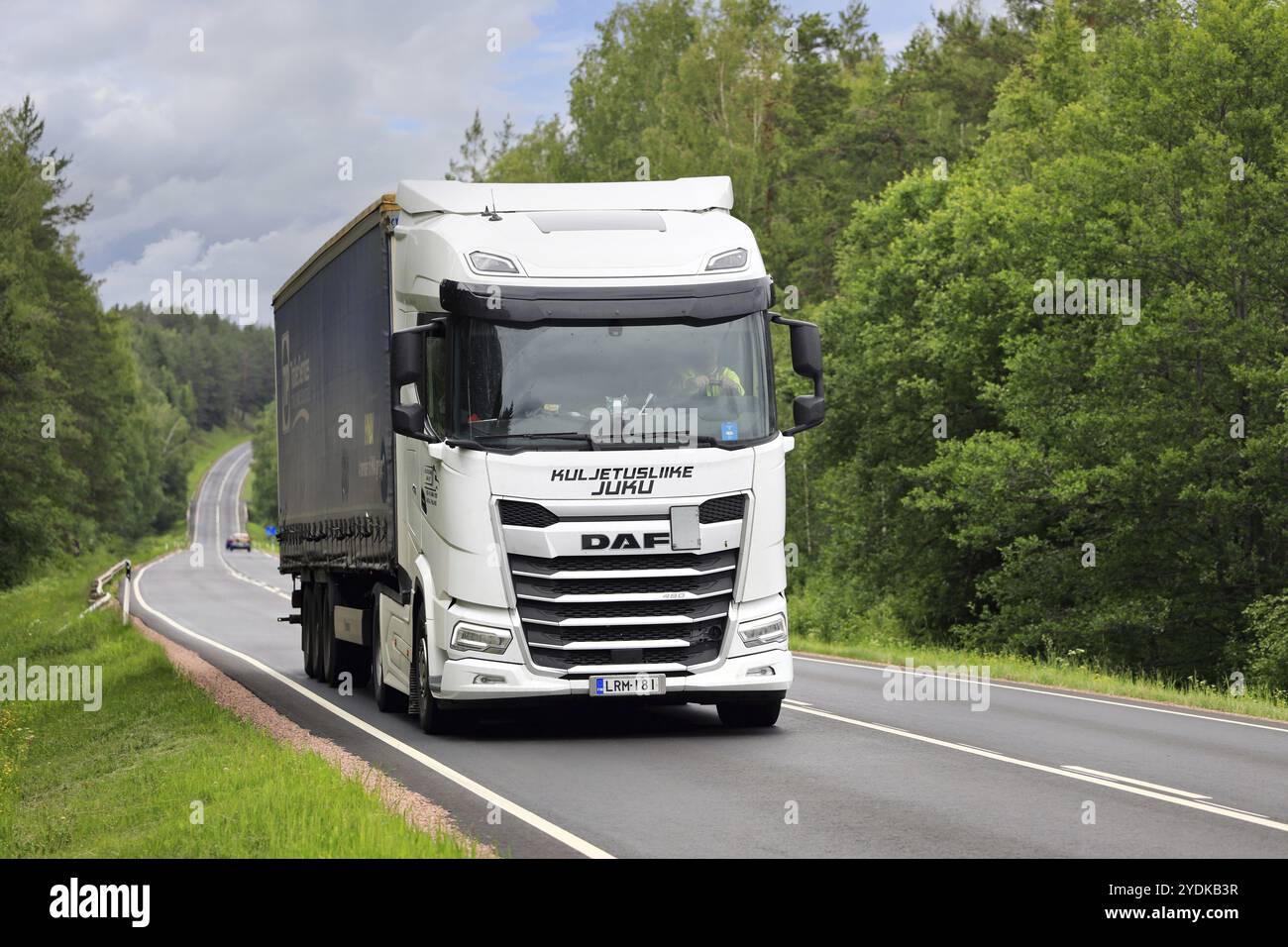 Der weiße DAF XG 480-Lkw zieht an einem Sommertag den Auflieger entlang der Autobahn 52 bergauf. Salo, Finnland. Juni 2024 Stockfoto