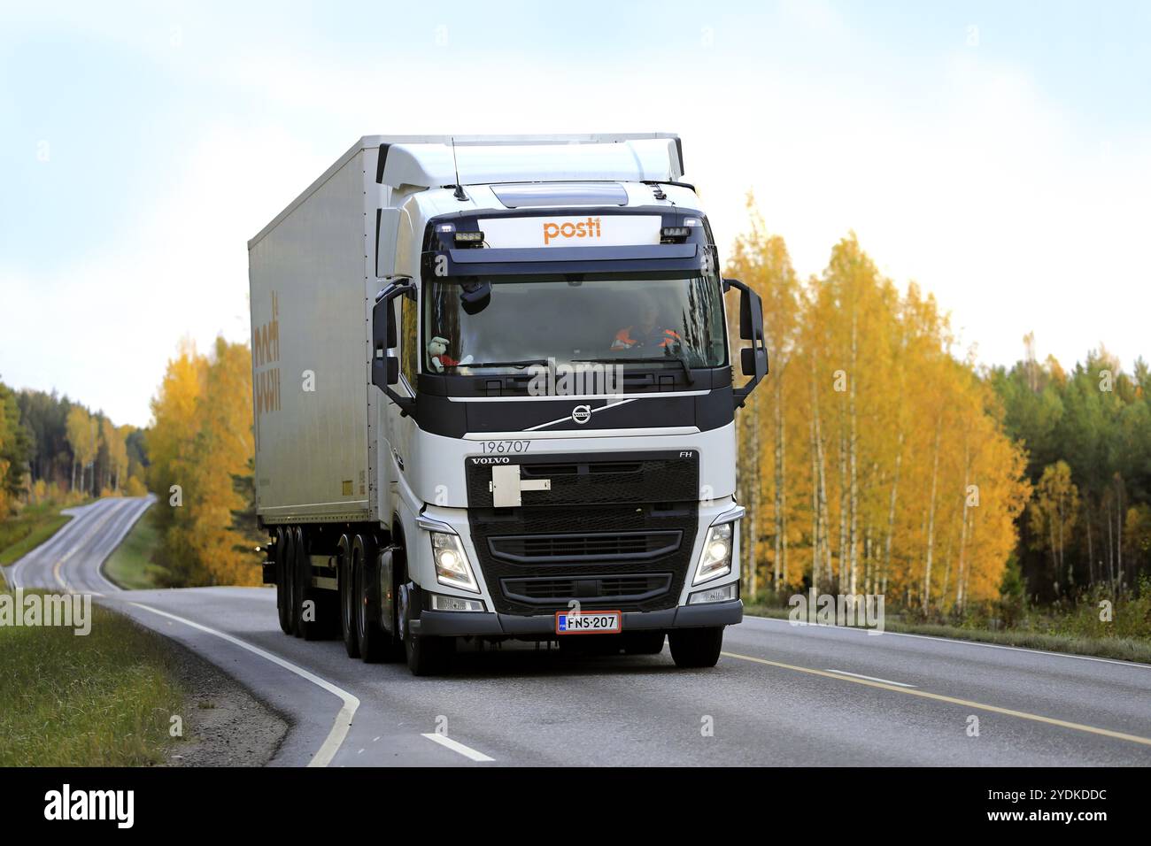 Weißer Volvo FH-Lieferwagen von Posti Kuljetus Oy auf der Autobahn 52 in der Herbstdämmerung. Salo, Finnland. Oktober 2019 Stockfoto