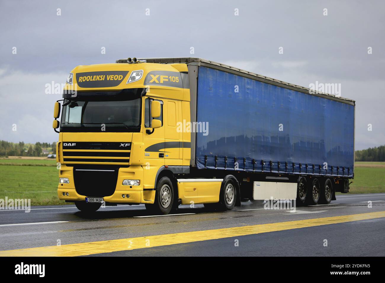 JOKIOINEN, FINNLAND, 4. SEPTEMBER 2016: Der gelbe DAF XF 105,460 von Rooleksi Veod transportiert einen Anhänger mit Kurvenschutz auf Asphaltstraße mit gelber Markierung Stockfoto