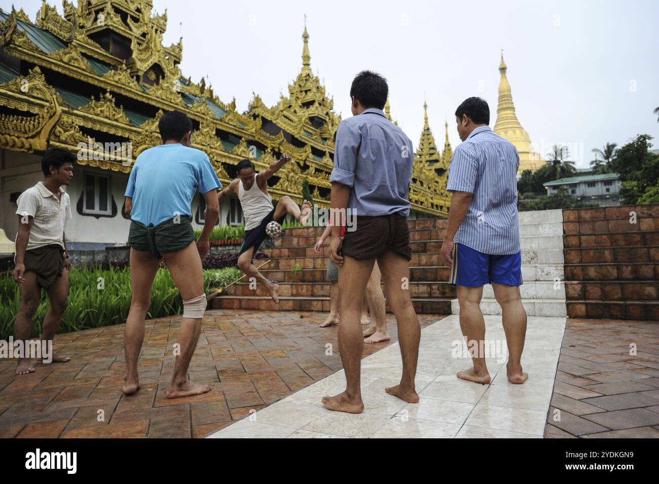 25.08.2013, Yangon, Myanmar, Asien, Eine Gruppe von Männern spielt Chinlone vor dem Tempelbereich der Shwedagon-Pagode. Das Spiel ist der Nationalsport von Stockfoto