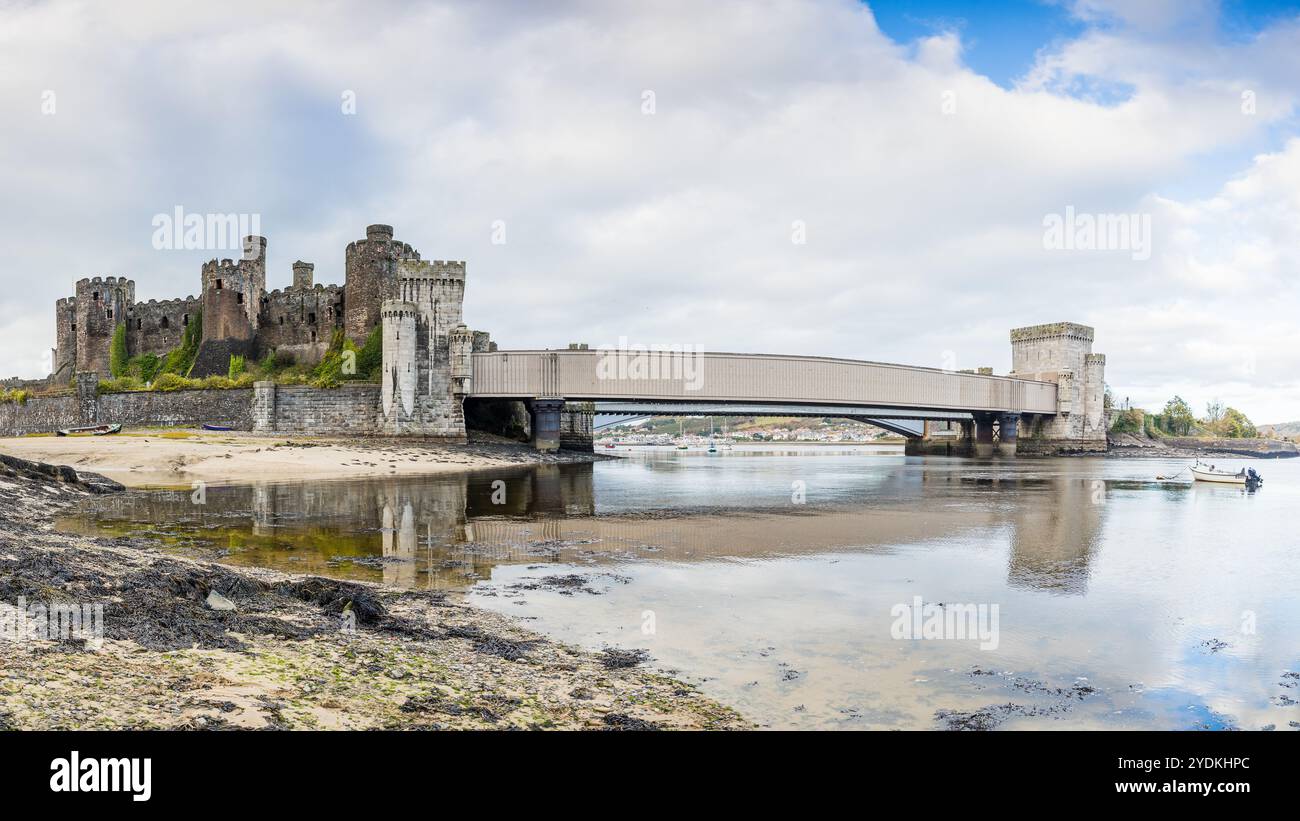 Ein HDR-Panorama mit mehreren Bildern von Conwy Castle und der Conwy Suspension Bridge, das sich bei Ebbe am 26. Oktober 2024 in Nordwales spiegelt. Stockfoto