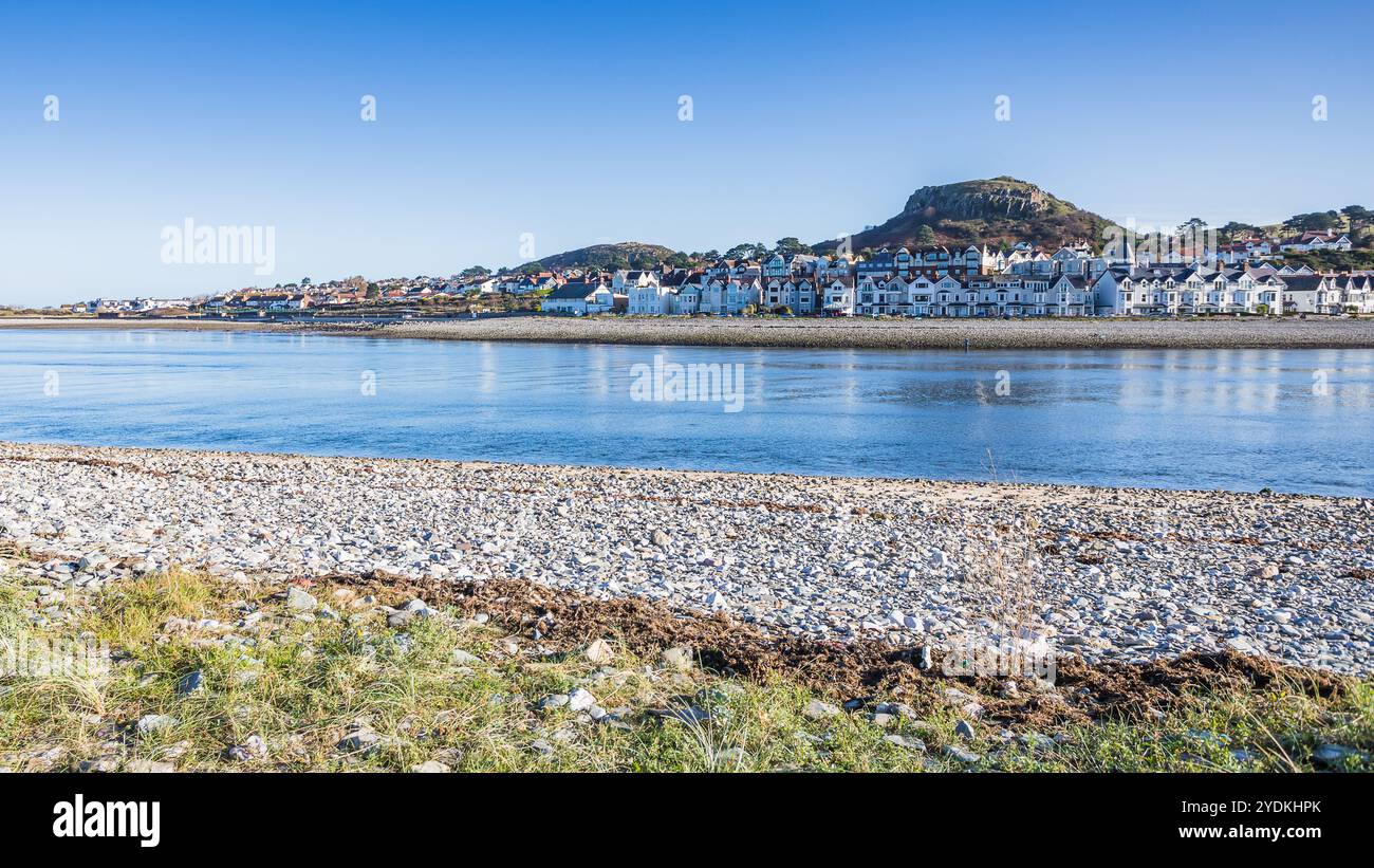 Eine lange Reihe von großen Häusern säumen die Küste von Deganwy an der Küste von Nordwales, die auf der anderen Seite der Mündung von Conwy dargestellt wird. Stockfoto