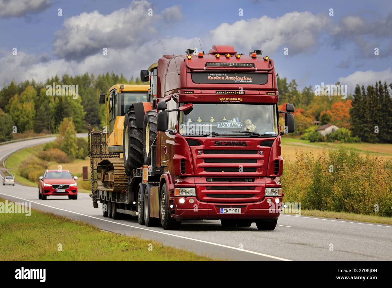 Der Auflieger Red Scania VeeTrucks Oy transportiert Baumaschinen im Verkehr der Autobahn 52 an einem Herbsttag. Salo, Finnland. September 2021 Stockfoto