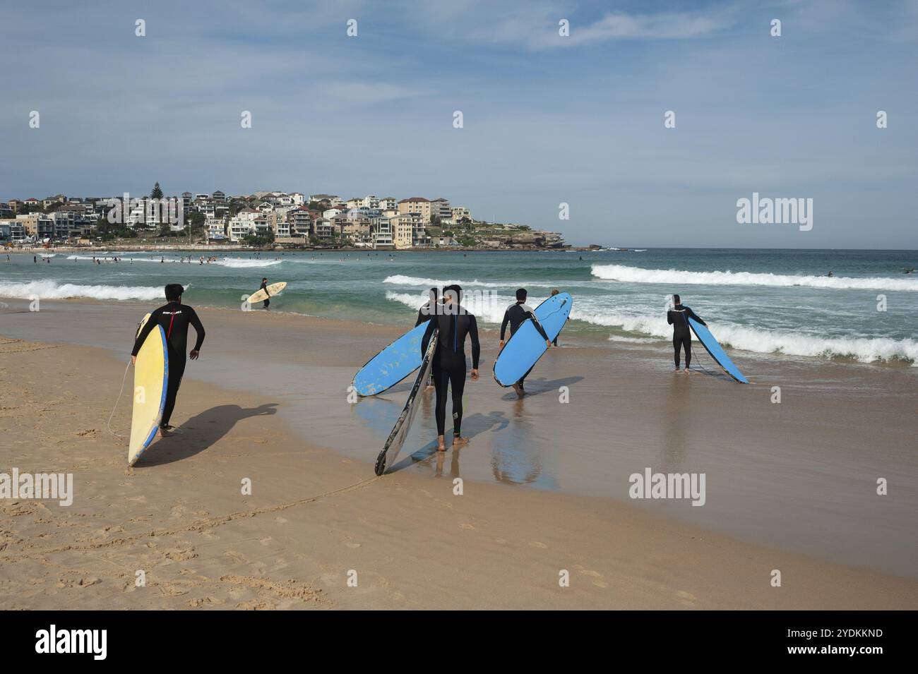 27.09.2019, Sydney, New South Wales, Australien, Junge Männer in Neoprenanzügen tragen ihre Surfbretter in Richtung Meer, während sie an einem Surfkurs in Bon teilnehmen Stockfoto