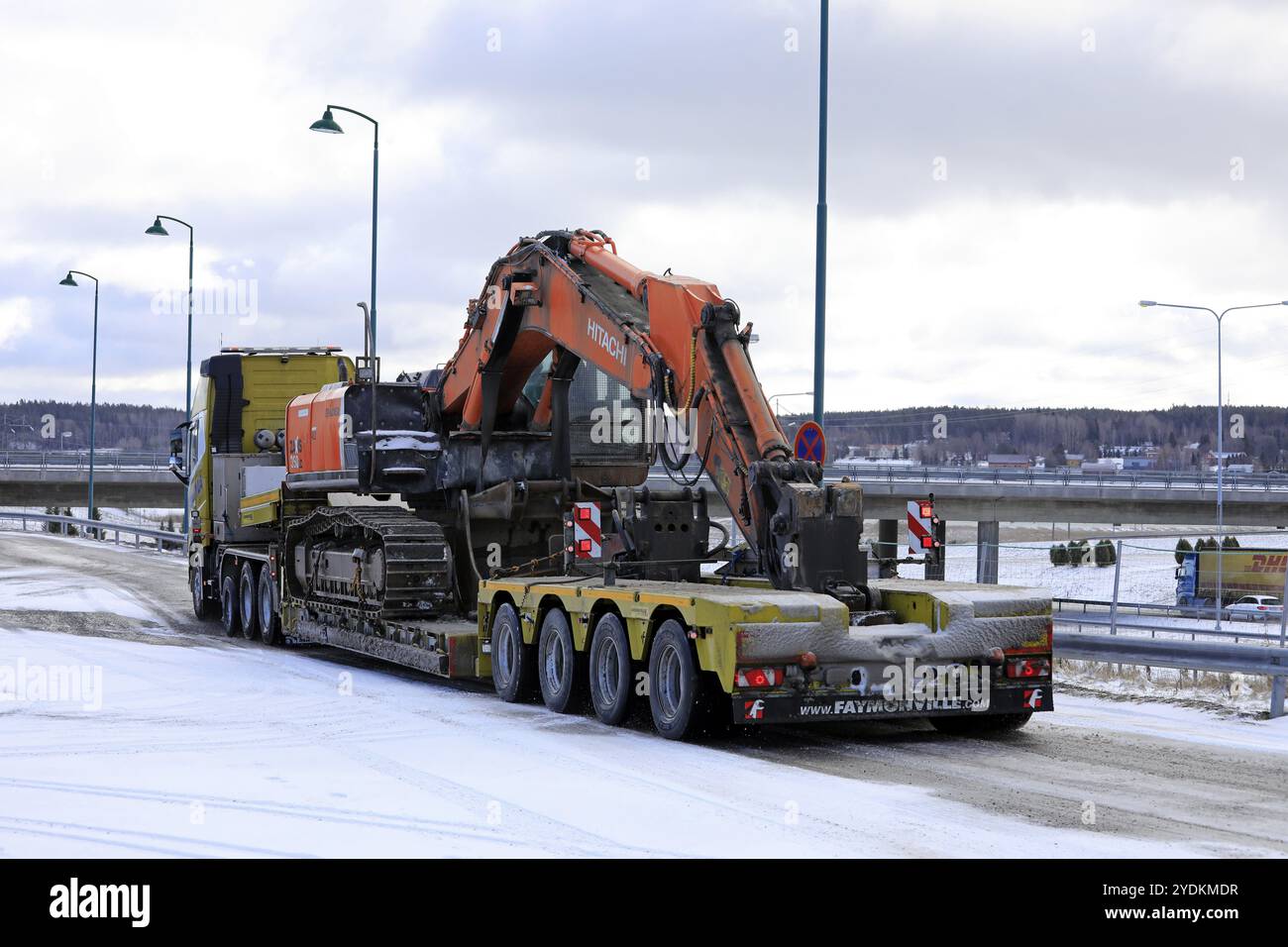 Salo, Finnland, 9. März 2019: Volvo FH16 Lkw mit Tieflader Faymonville Anhänger mit einem Hitachi ZX 350LC Raupenbagger am Wintertag, EUR Stockfoto