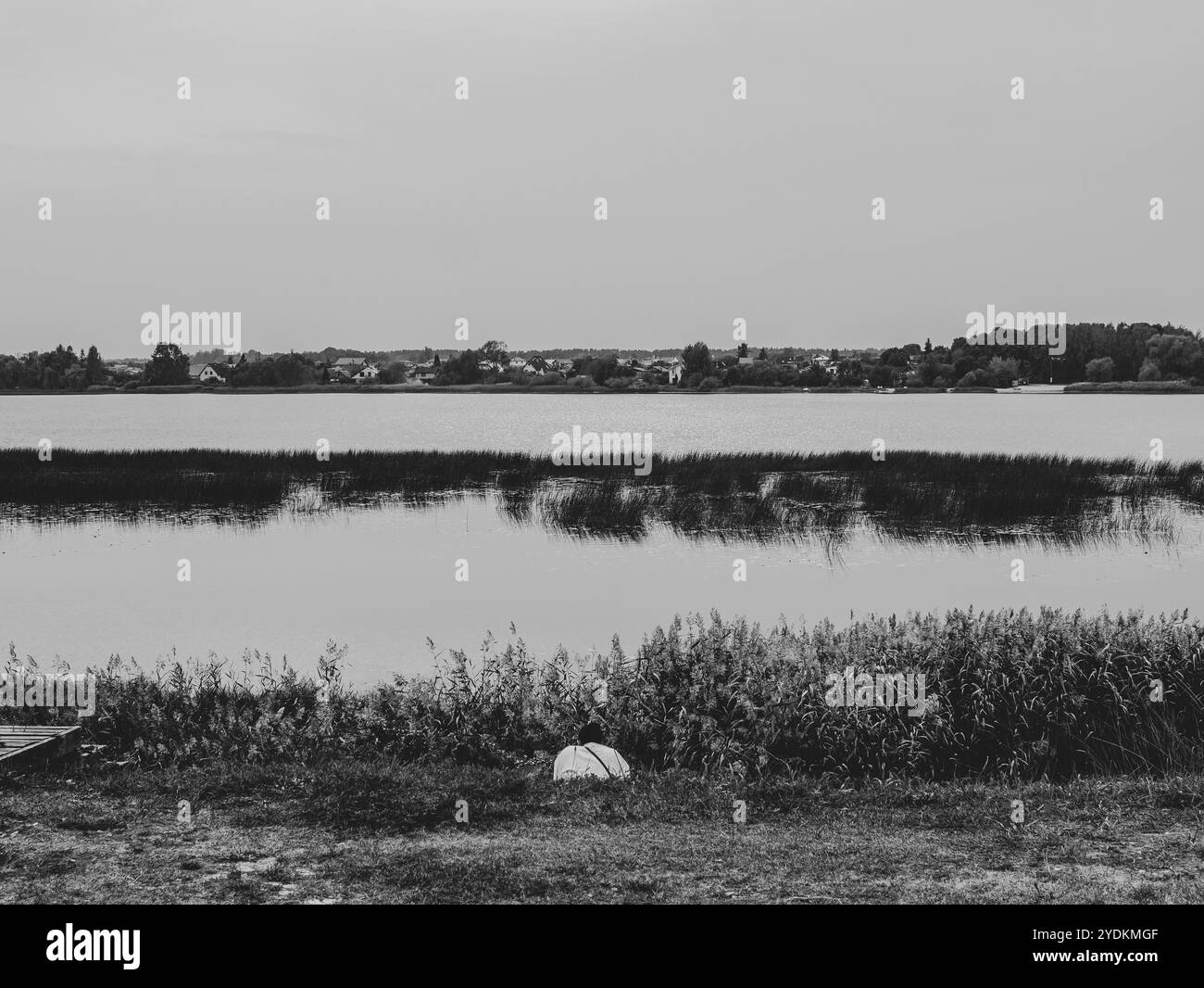 Einsame Frau, die allein am Herbstfluss sitzt, zurück view.autumn Landschaft.Riga.Lettland.30.09.2024 Stockfoto