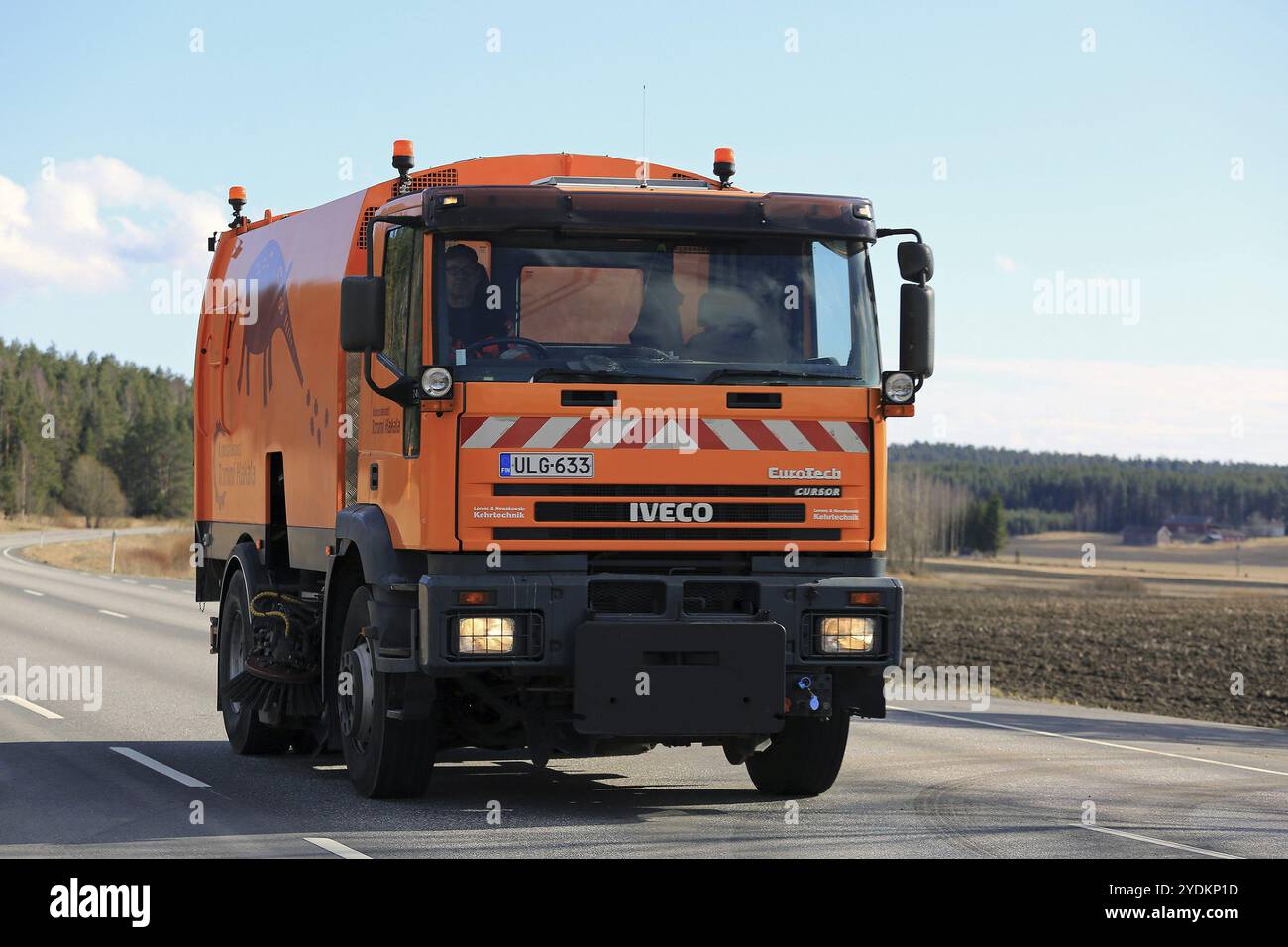 SALO, FINNLAND, 21. APRIL 2017: Der orange Iveco Eurotech Cursor Kehrwagen fährt im Frühjahr auf der Autobahn Stockfoto