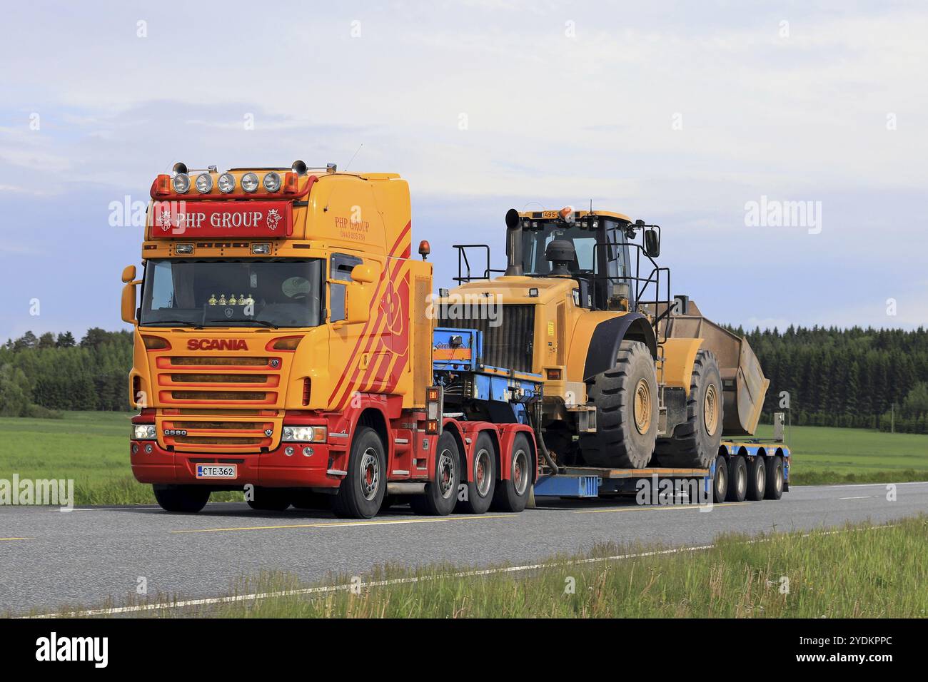 JOKIOINEN, FINNLAND, 16. JUNI 2017: Maßgeschneiderter Scania G580-Lkw-Schwanenhalsanhänger der PHP-Gruppe transportiert großen Cat 980H-Radlader auf der Autobahn AT Stockfoto