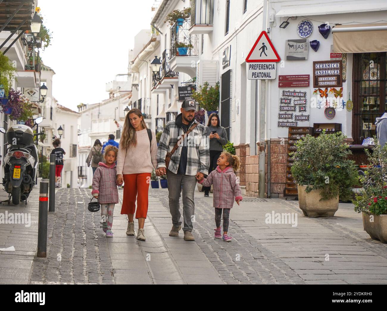 Eine junge Familie schlendert durch die Straßen von Mijas Pueblo, Malaga. Costa del Sol, Andalusien, Spanien. Stockfoto