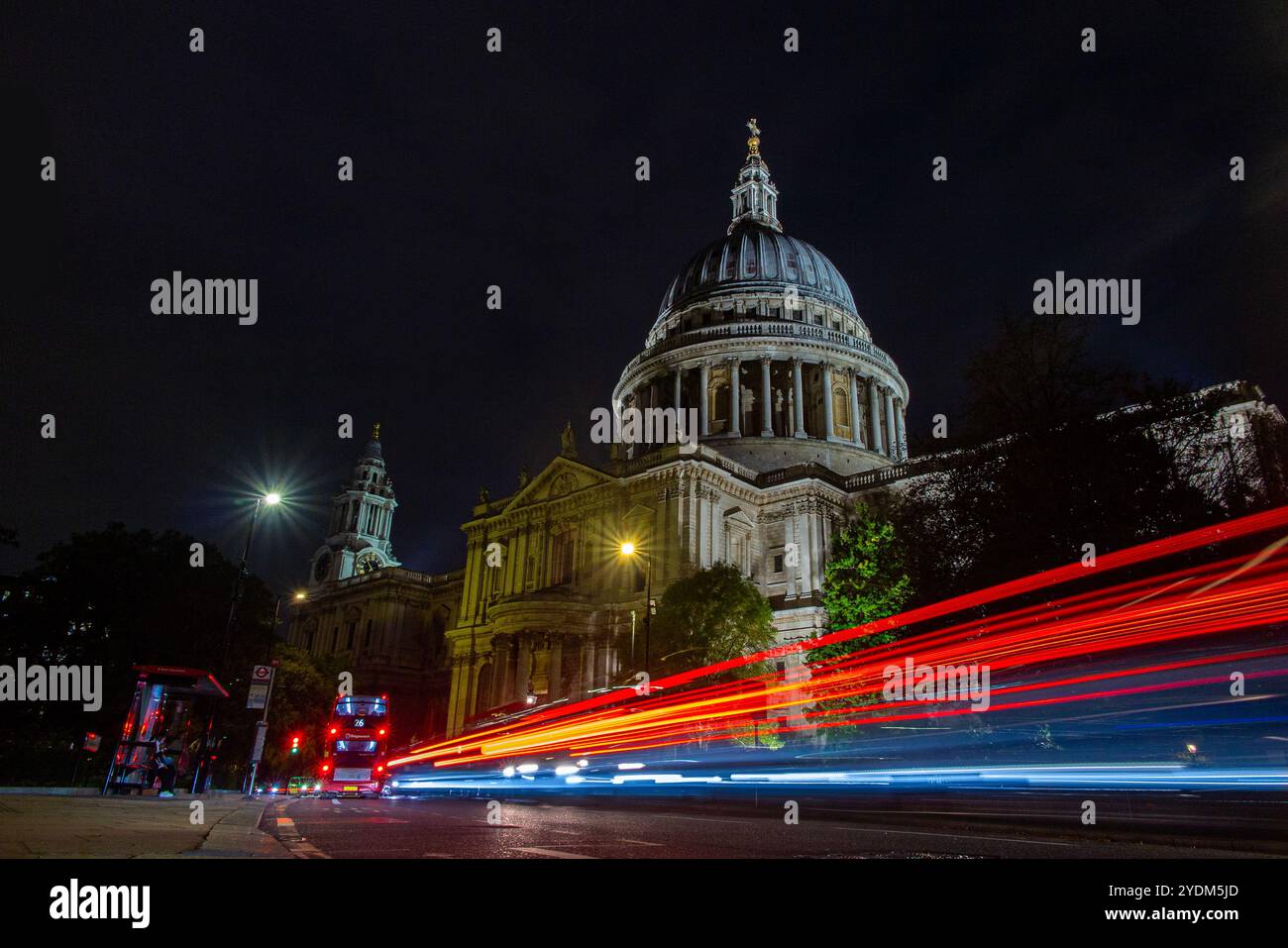 ST. PAUL'S CATHEDRAL BEI NACHT MIT AUTO UND NACHTBUS-LICHTBAHNEN Stockfoto