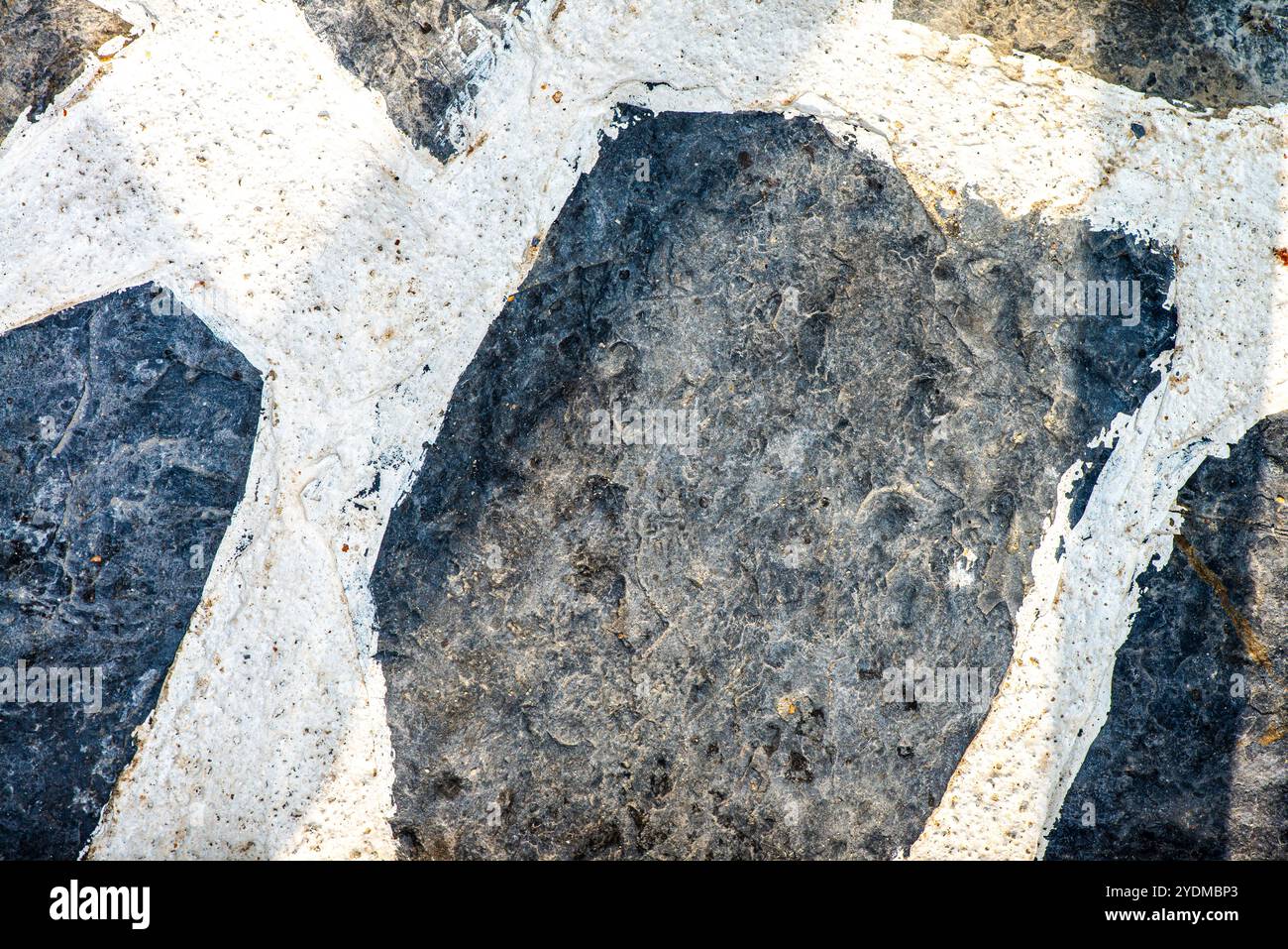 Eine detaillierte Nahaufnahme eines Natursteinhintergrunds mit Erdtönen und einzigartigen Mustern, die jedem Design Tiefe und Charakter verleihen. Stockfoto