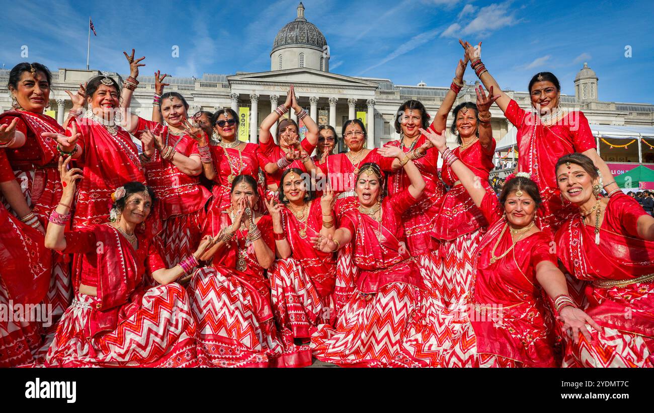 London, Großbritannien. Oktober 2024. Die von Geeta Shah organisierte Women to Women Group besteht aus Frauen über 60 Jahren, die gerne tanzen. Darsteller der farbenfrohen Eröffnungstanz-Sequenz mit rund 200 Tänzern aus acht verschiedenen Londoner Tanzschulen in traditionellen Kostümen, die dieses Jahr die Geschichte des Lord Rama mit ihrem Tanz erzählen. Die Feier des Diwali, das Festival of Lights, der Hauptstadt am Trafalgar Square, zeigt kulturelle Elemente aus Londons Hindu-, Sikh- und Jain-Gemeinden mit lebendigem Tanz, Musik, Aktivitäten, Marktständen und Essen. Stockfoto
