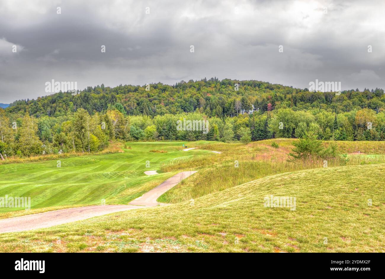 Ein grüner Golfplatz inmitten der sanften Hügel mit bewölktem Himmel an einem schönen Sommertag in Kanada Stockfoto