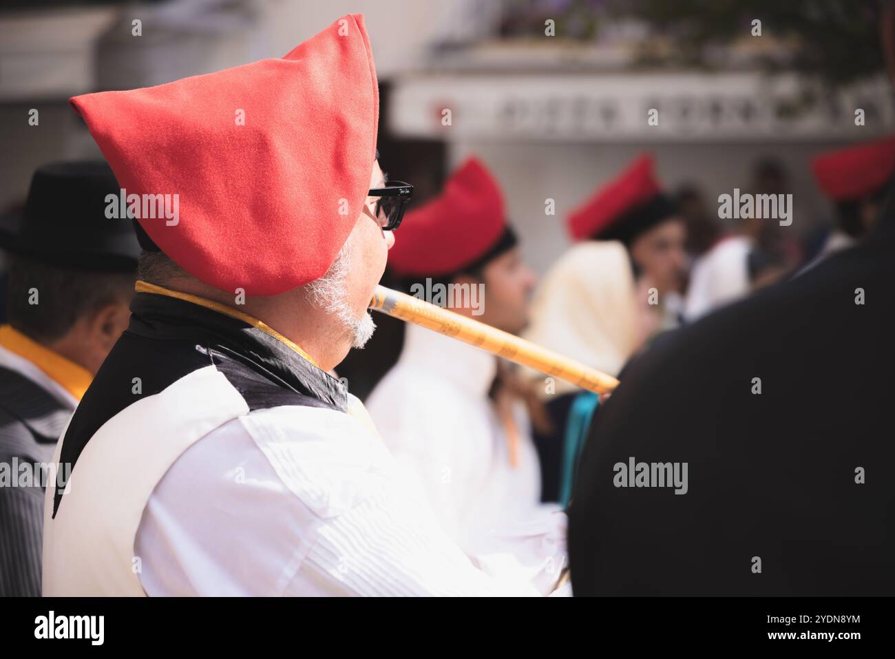 Ibiza, Spanien - 8. Oktober 2023: Musiker in traditioneller Baskenbekleidung spielt bei einem Kulturfestival in der Altstadt von Ibiza eine Flöte und zeigt lebendige Atmosphäre Stockfoto