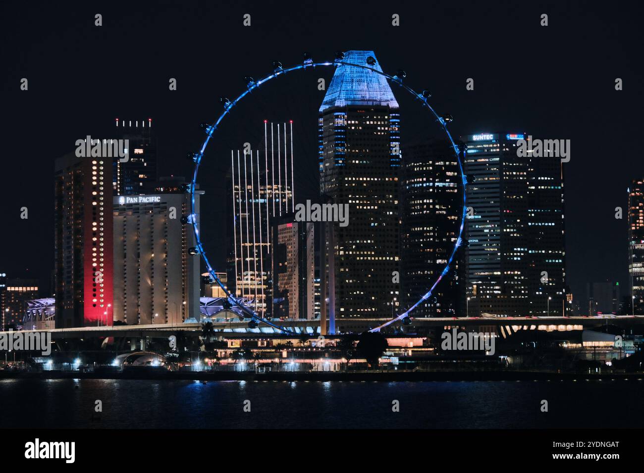Singapur - 16. August 2024: Skyline der Stadt und das Singapore Flyer Ferris Rad in der Marina Bay bei Nacht Stockfoto