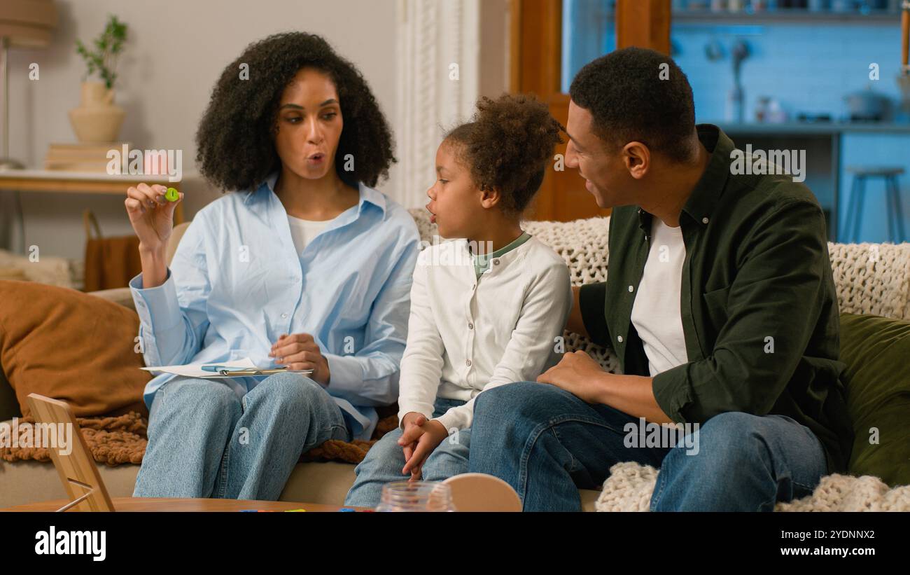 Afroamerikanische Mutter Sprachtherapeutin Hold Letter unterrichten Aussprache Ton Wort sprechen korrekte Aussprache Vater Vater Vater Familie Kind zusammen Teamarbeit Stockfoto