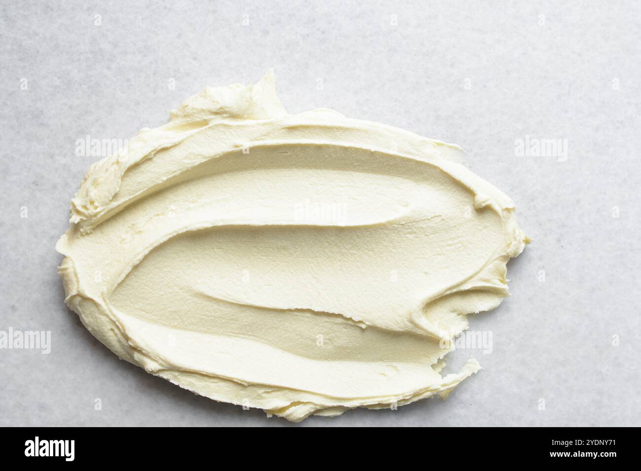 Draufsicht auf Creme Buttercreme zum Dekorieren von Kuchen, seidenweiche amerikanische Buttercreme mit Mustern, cremestrukturierter Hintergrund Stockfoto