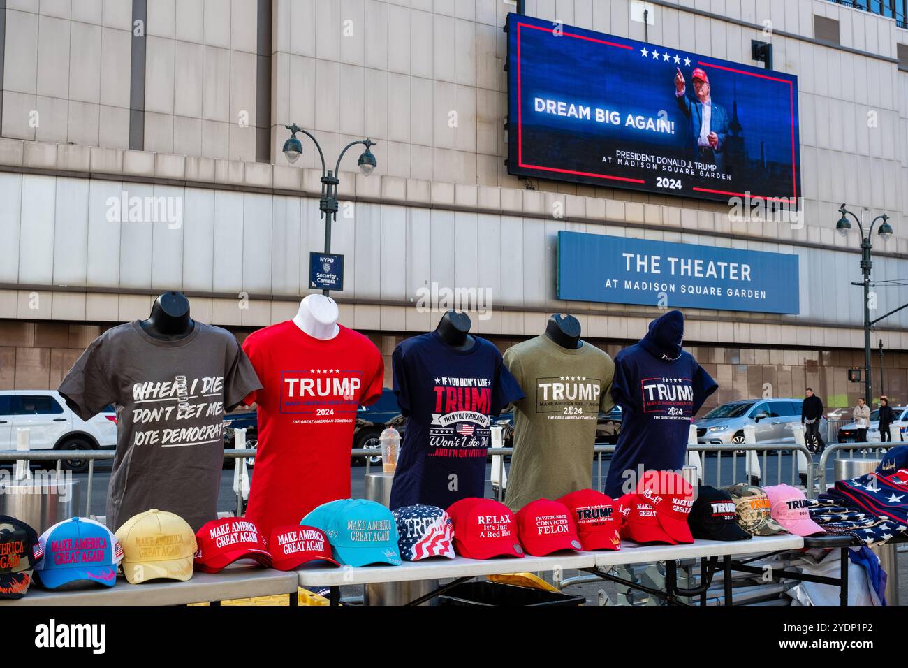 New York, NY, USA. Oktober 2024. Vor dem Madison Square Garden versammeln sich vor einer abendlichen Kundgebung Massen von Anhängern Donald Trump, von denen viele Mützen und Hemden der Marke MAGA oder Trump tragen. Eine Ausstellung von Trump-Mützen und T-Shirts auf der 8th Avenue gegenüber vom Madison Square Garden. Quelle: Ed Lefkowicz/Alamy Live News Stockfoto