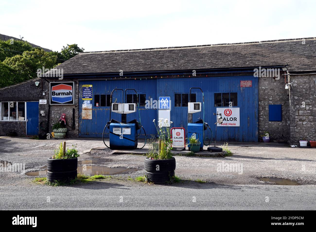 Benzinpumpen und die Werkstatt für die Fahrzeugreparatur in der Kettlewell Garage im Dorf Kettlewell der Yorkshire Dales. Stockfoto