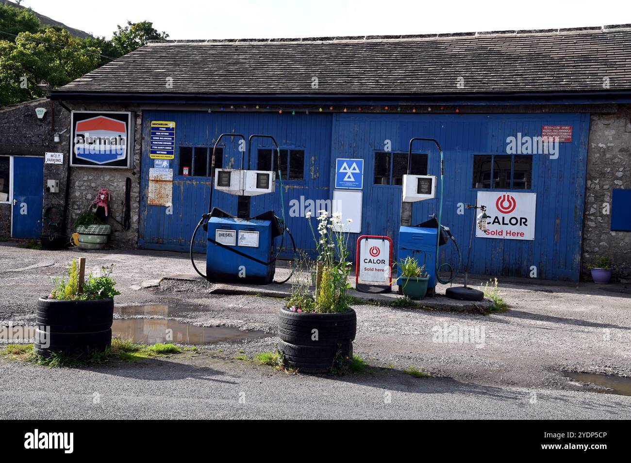 Benzinpumpen und die Werkstatt für die Fahrzeugreparatur in der Kettlewell Garage im Dorf Kettlewell der Yorkshire Dales. Stockfoto