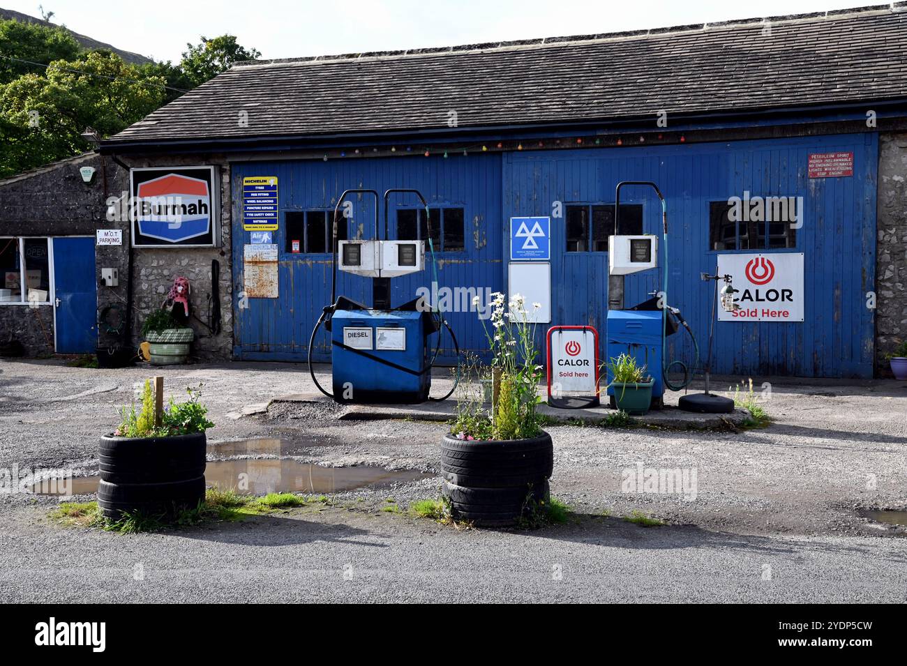 Benzinpumpen und die Werkstatt für die Fahrzeugreparatur in der Kettlewell Garage im Dorf Kettlewell der Yorkshire Dales. Stockfoto