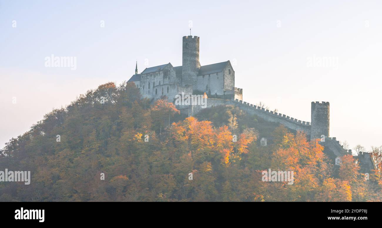 Der Herbst verwandelt die Burg Bezdez in einen lebendigen Anblick, wo die gotische Architektur stolz inmitten der bunten Bäume steht und die reiche Geschichte der tschechischen Länder widerspiegelt. Stockfoto