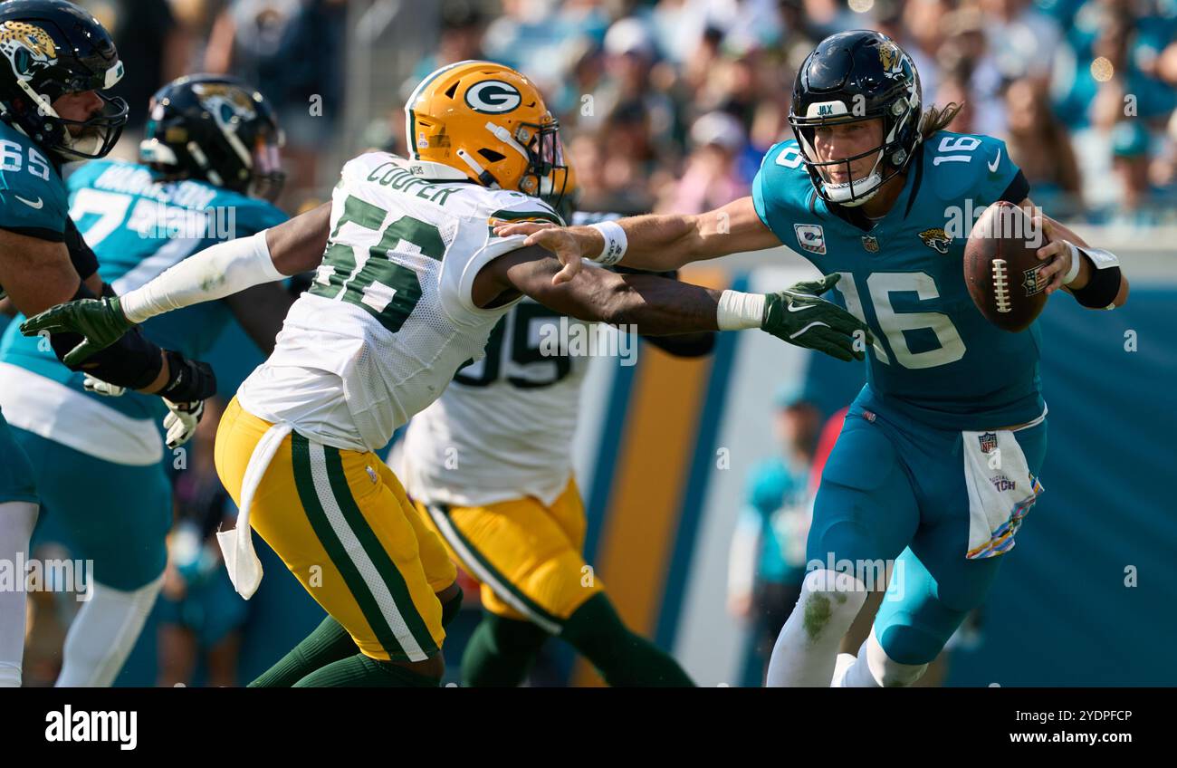 Jacksonville, Florida, USA. Oktober 2024. National Football League, Jacksonville Jaguars gegen Green Bay Packers. Jacksonville Jaguars Quarterback Trevor Lawrence (16) versucht, dem Linebacker Edgerrin Cooper (56) der Green Bay Packers zu entkommen. Foto: Tim Davis/Alamy Live News Stockfoto