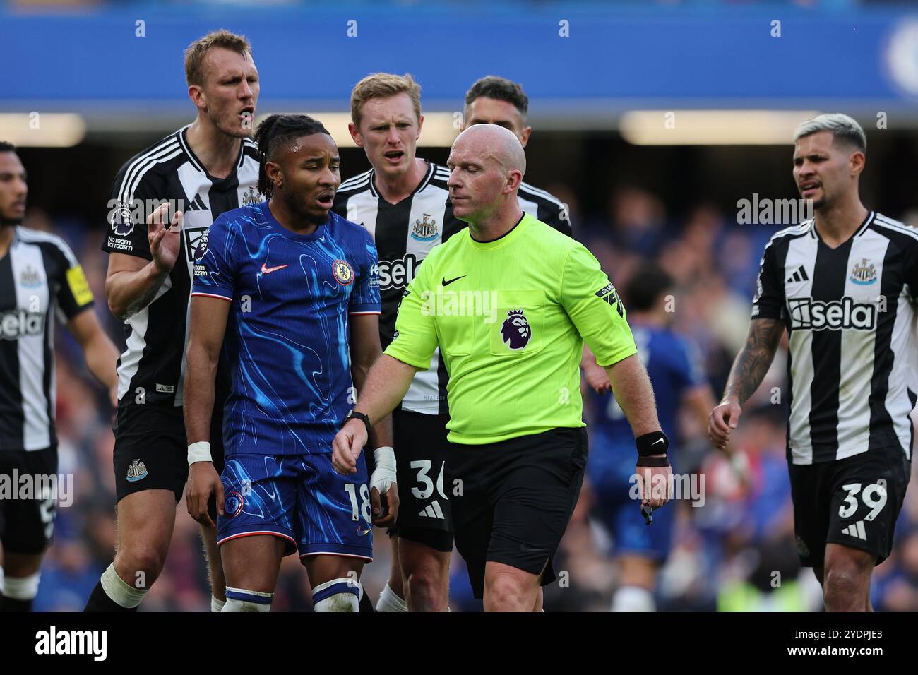 27. Oktober 2024; Stamford Bridge, Chelsea, London, England: Premier League Football, Chelsea gegen Newcastle United; Schiedsrichter Simon Hooper versucht, ruhig zu bleiben, während er von Christopher Nkunku aus Chelsea, Dan Burn, Sean Longstaff und Fabian Schar aus Newcastle United gekrönt wird Stockfoto