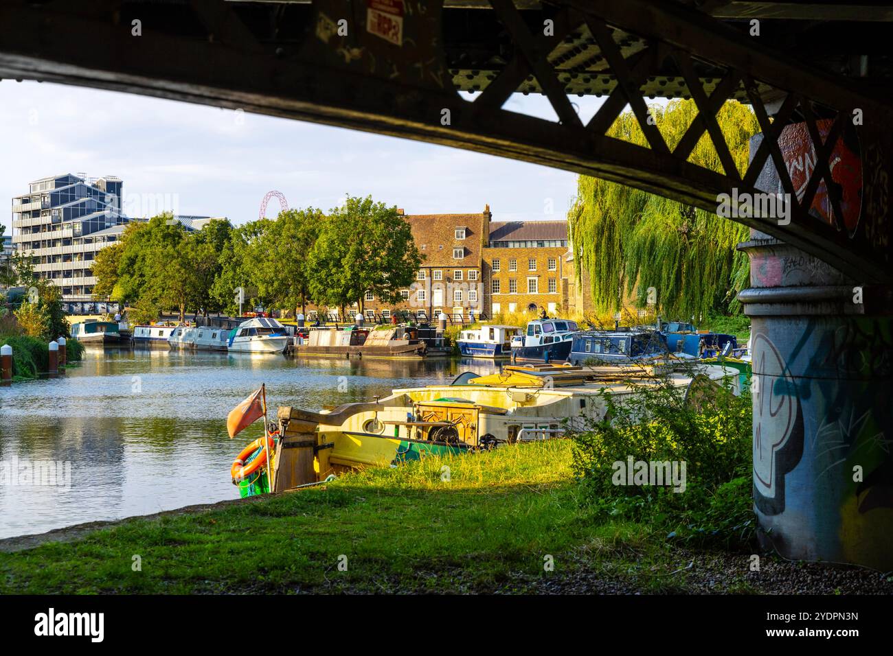 Blick auf Boote auf dem Fluss Lea und Three Mills Island von der Under Bow Locks Railway Bridge, London, England Stockfoto