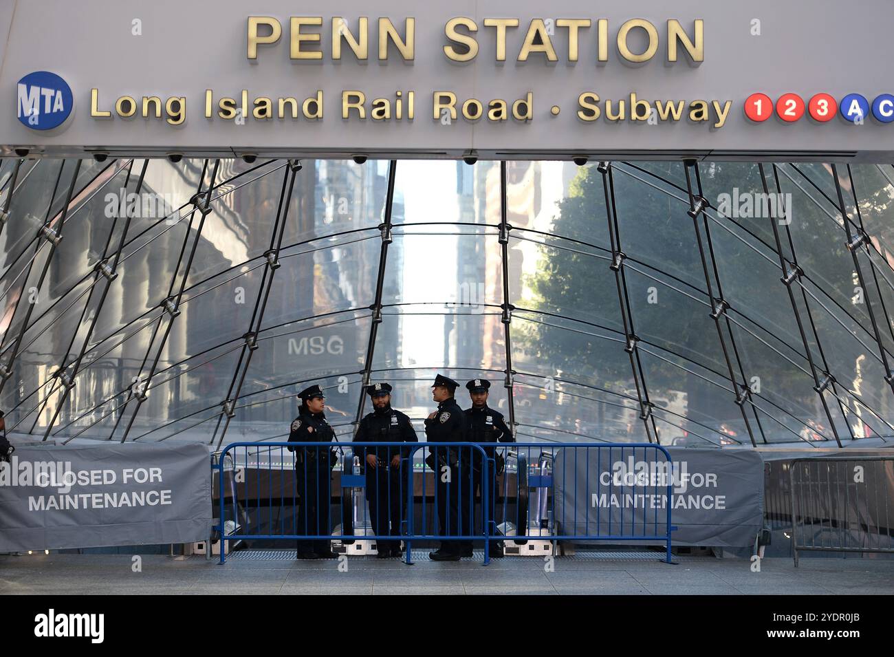 New York, USA. Oktober 2024. Mitglieder des NYPD stehen am geschlossenen Eingang der 33rd Street zur Penn Station neben dem Madison Square Garden, wo der ehemalige Präsident Donald Trump eine politische Kundgebung abhält, in New York, NY, 27. Oktober 2024. (Foto: Anthony Behar/SIPA USA) Credit: SIPA USA/Alamy Live News Stockfoto