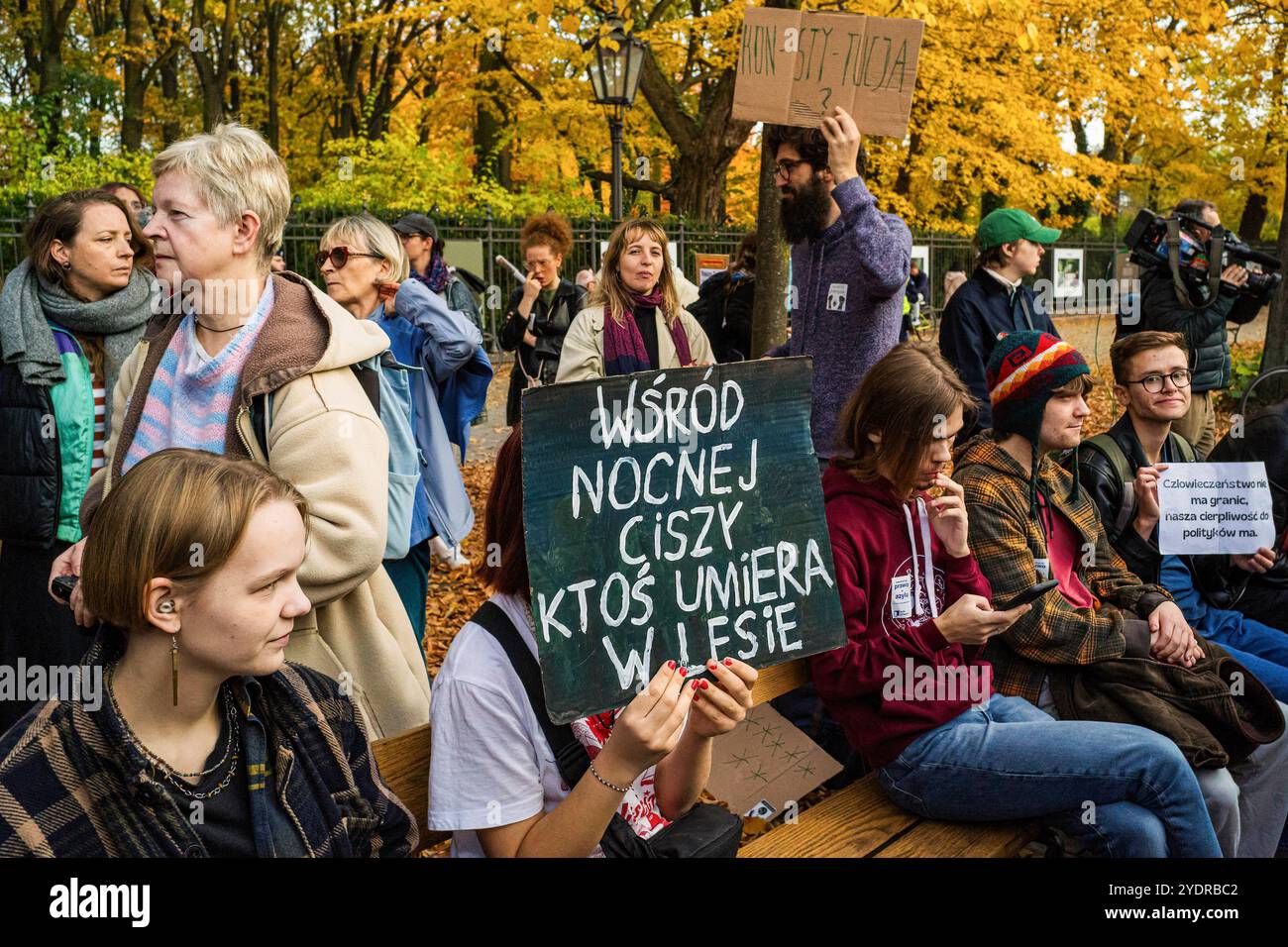 Eine Demonstrantin bedeckt ihr Gesicht mit einem Plakat auf Polnisch, auf dem steht: „Im Schweigen der Nacht stirbt jemand im Wald“, und verweist auf die Situation an der Polnisch-weißrussischen Grenze während der Kundgebung. Eine Ansammlung von Aktivistengruppen und Unterstützern kam zusammen, um gegen die Pläne der polnischen Regierung zu protestieren, das Asylrecht auszusetzen, was sie für ein Menschenrecht halten. Am 15. Oktober kündigte die polnische Regierung eine neue Migrationsstrategie für 2025-2030 an, in der die ëtemporary und die territoriale Aussetzung des Rechts auf Beantragung von asylumí vorgeschlagen werden. Es wird dies behauptet Stockfoto