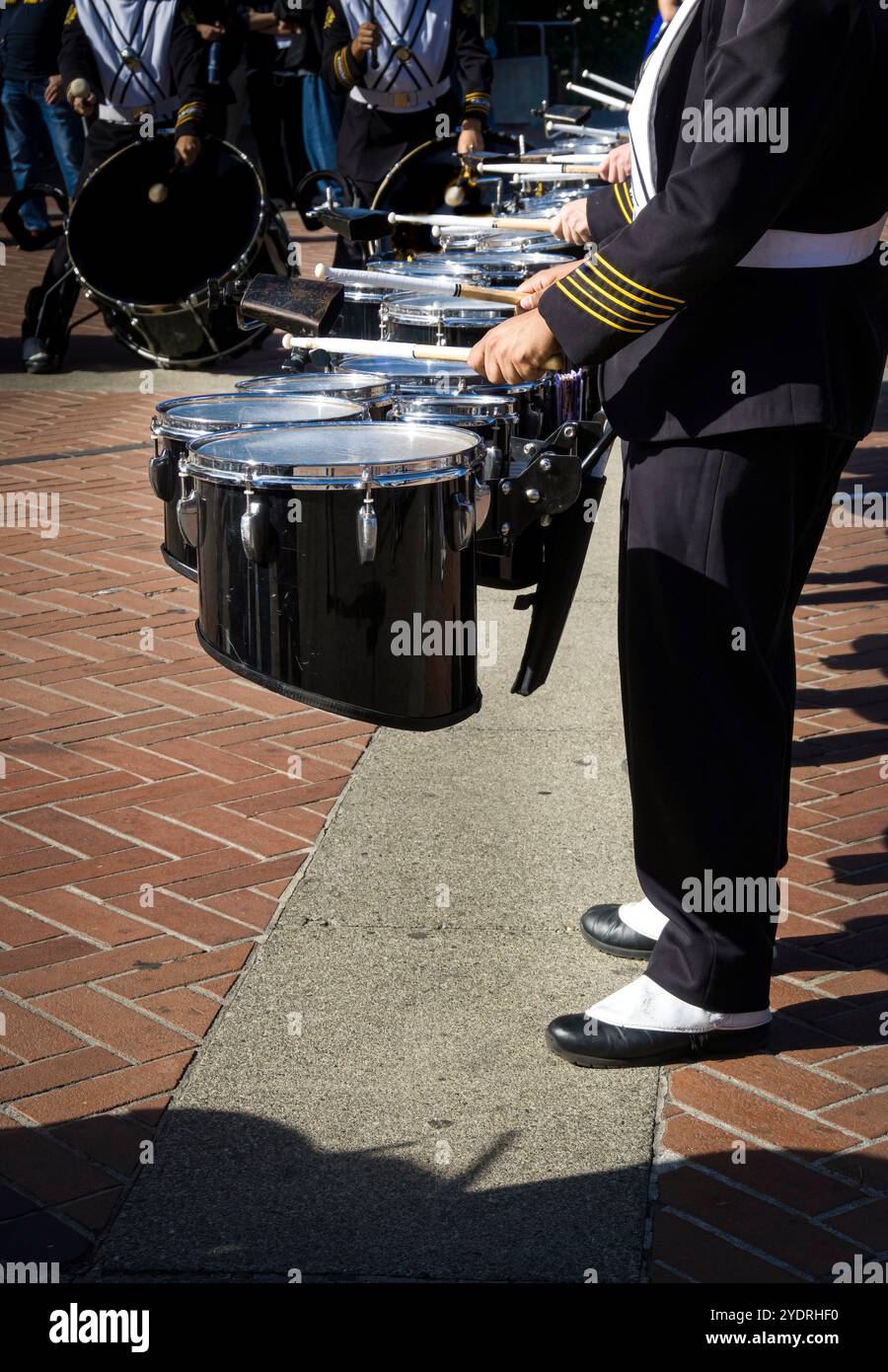 Eine Reihe marschender Bandtrommler, die Tenortrommeln spielen, auch bekannt als „Toms“. Stockfoto