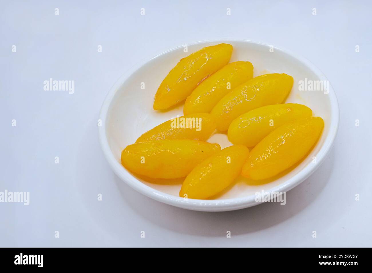 Med kanoon, ein thailändisches, verheißungsvolles Dessert in Form von Jackfruchtsamen, aus gedämpfter Mungbohnenpaste, Kokosmilch und Zucker, dann in Sirup gekocht Stockfoto