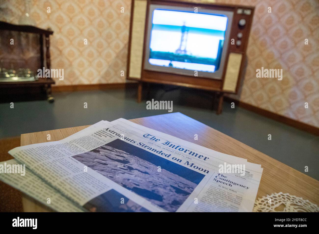 Ein Zimmer im Vintage-Stil mit der Überschrift "Astronauten auf dem Mond" auf einem Holztisch, mit einem Countdown auf einem alten Fernseher. Stockfoto