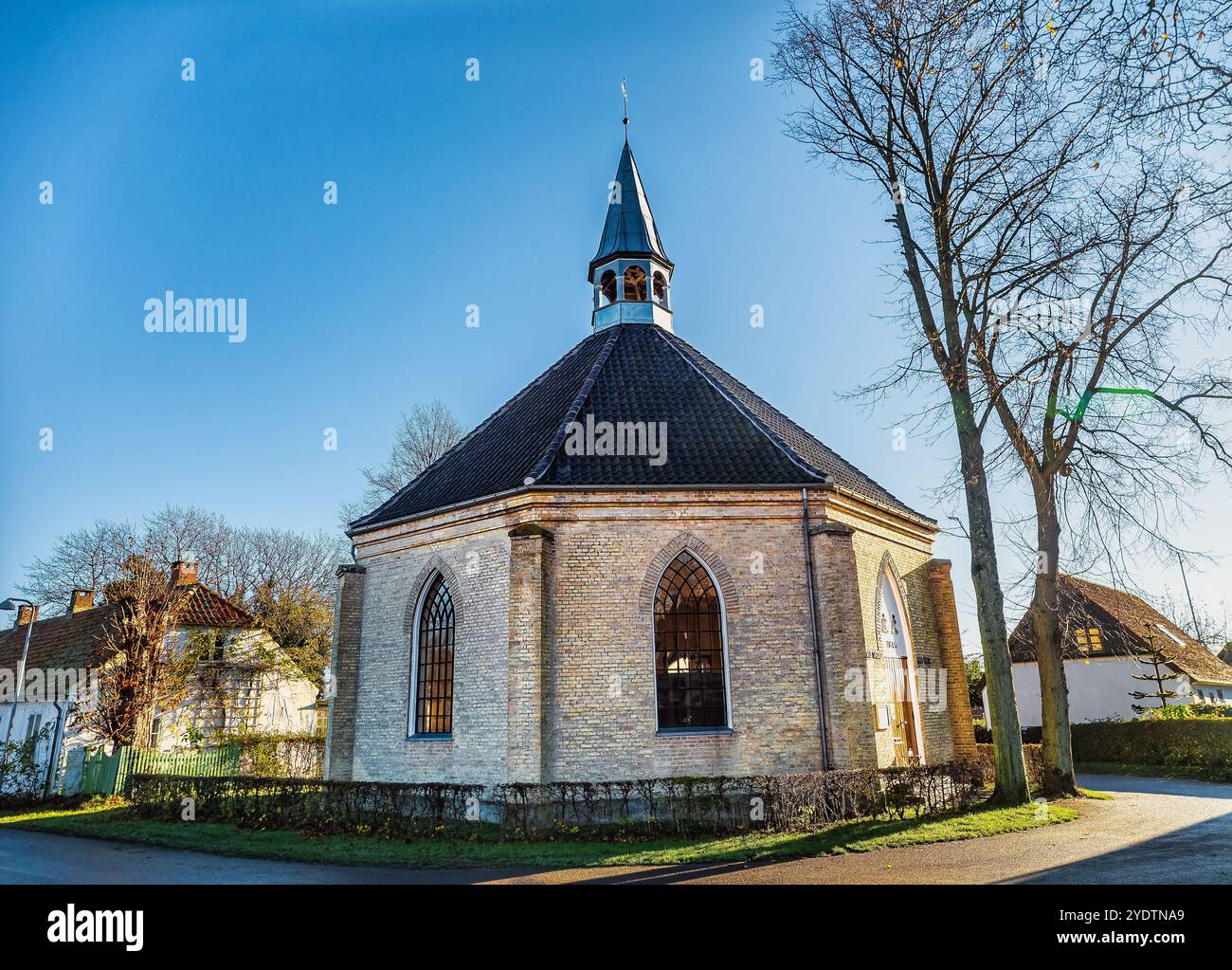 Nyord wunderschöner Blick auf eine historische, runde Backsteinkirche mit Bogenfenstern und einem unverwechselbaren Turm, an einem sonnigen Tag vor einem klaren blauen Himmel Stockfoto