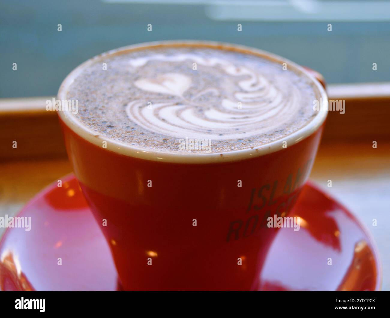 Rot glänzende Tasse heiße Schokolade auf einem Tisch Stockfoto