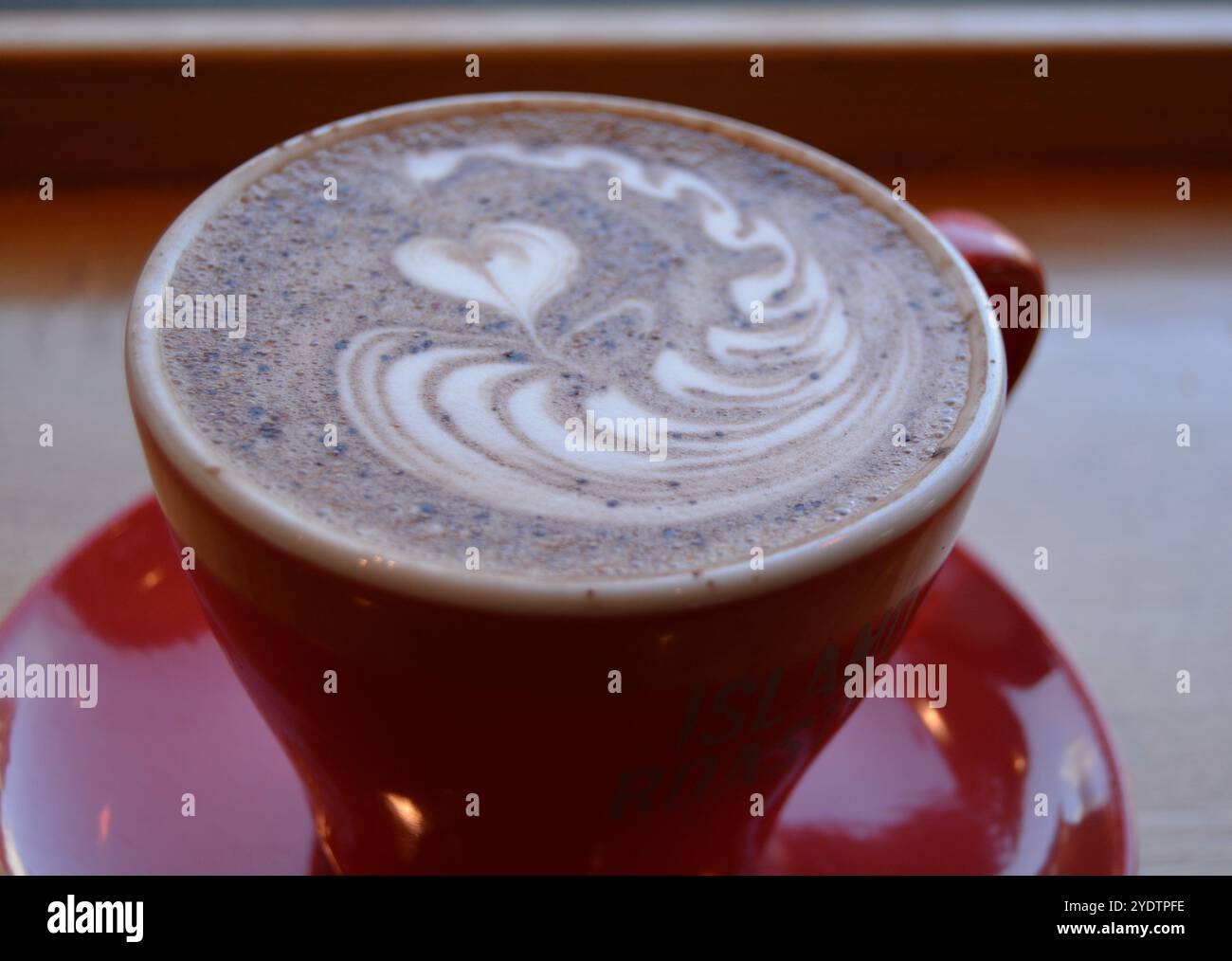 Rot glänzende Tasse heiße Schokolade auf einem Tisch Stockfoto