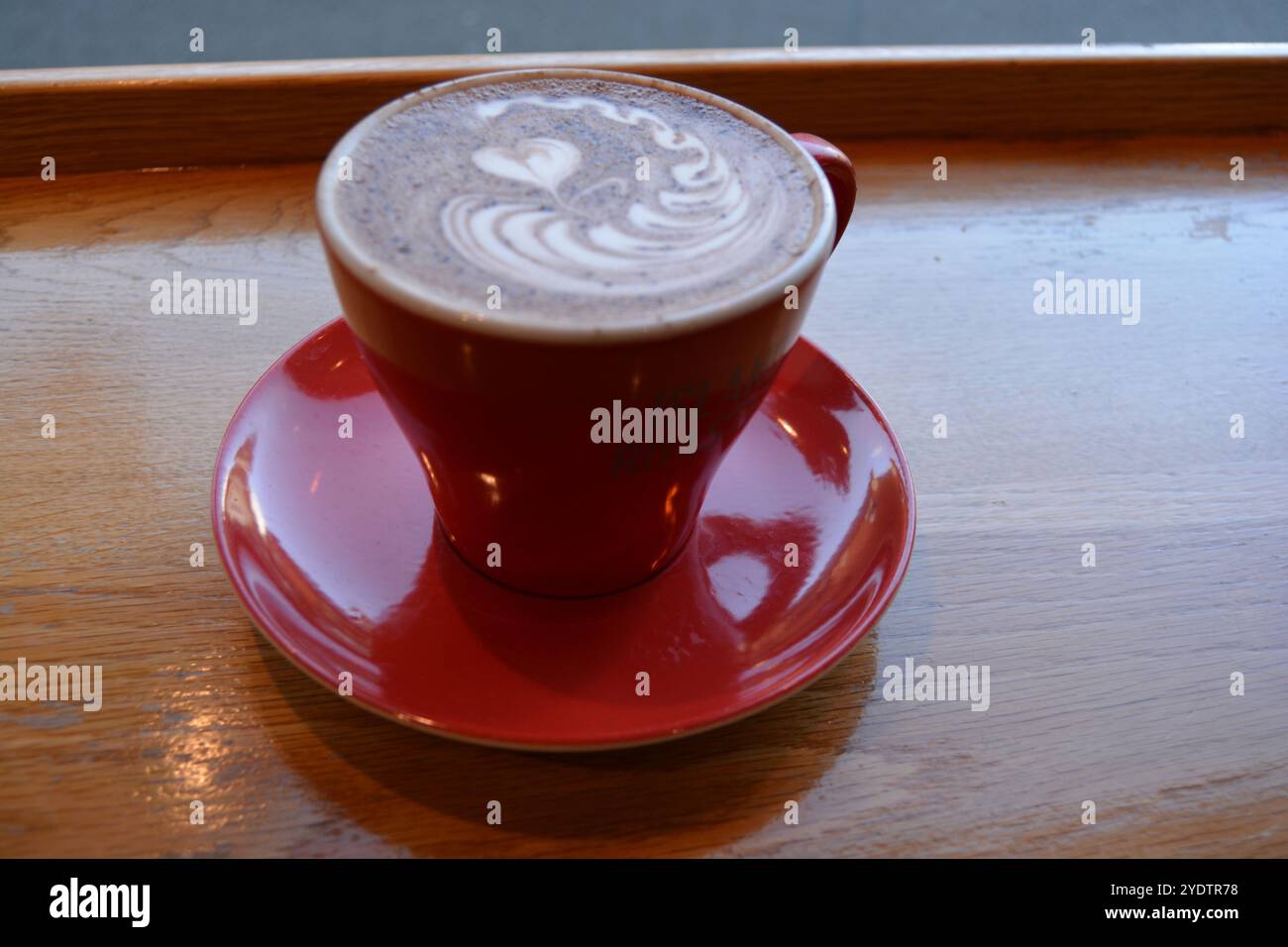 Rot glänzende Tasse heiße Schokolade auf einem Tisch Stockfoto