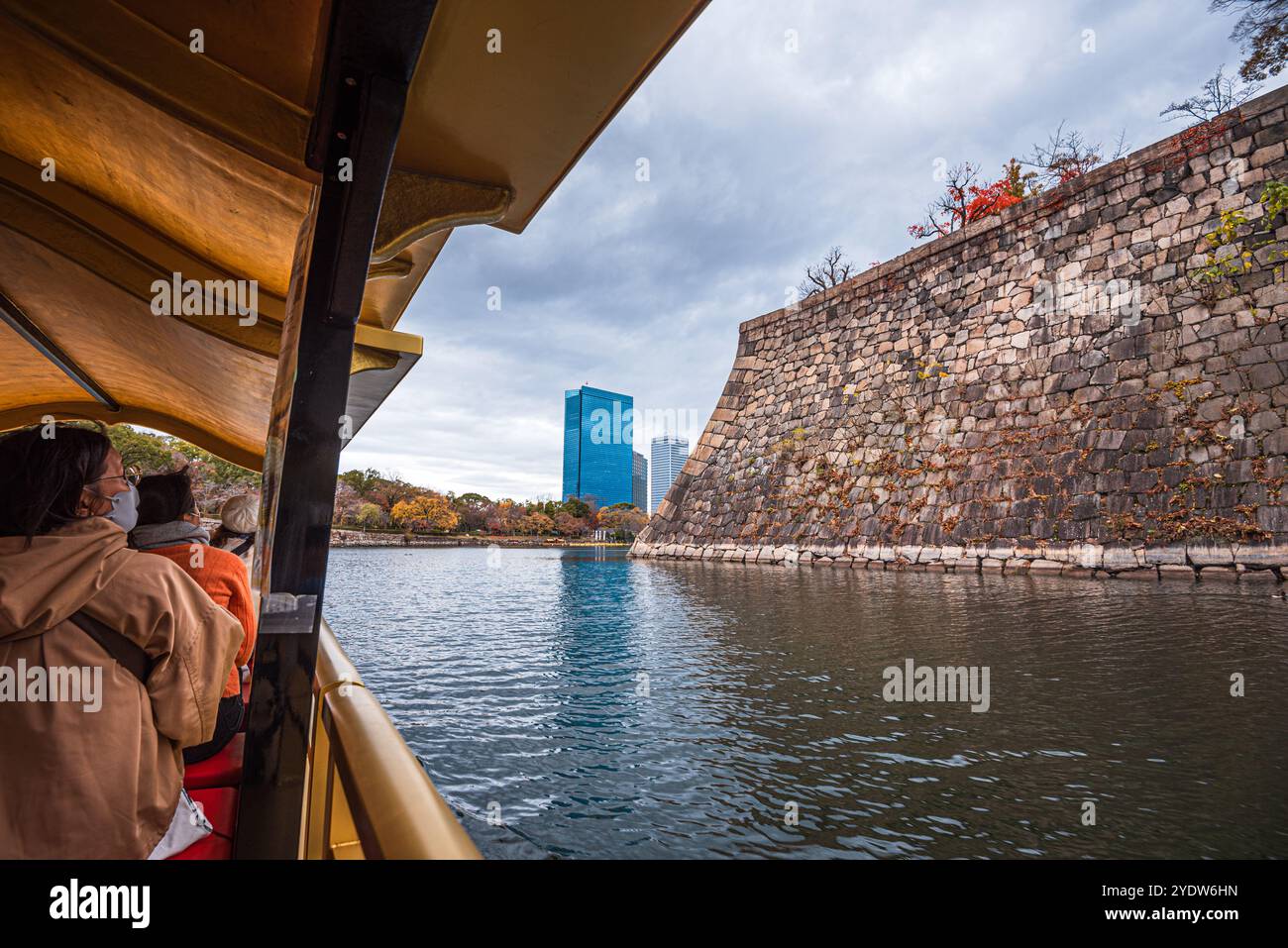 Blick von einem traditionellen Boot auf den Burggraben von Osaka und Mauern im Herbst mit Besuchern, Osaka, Honshu, Japan, Asien Stockfoto