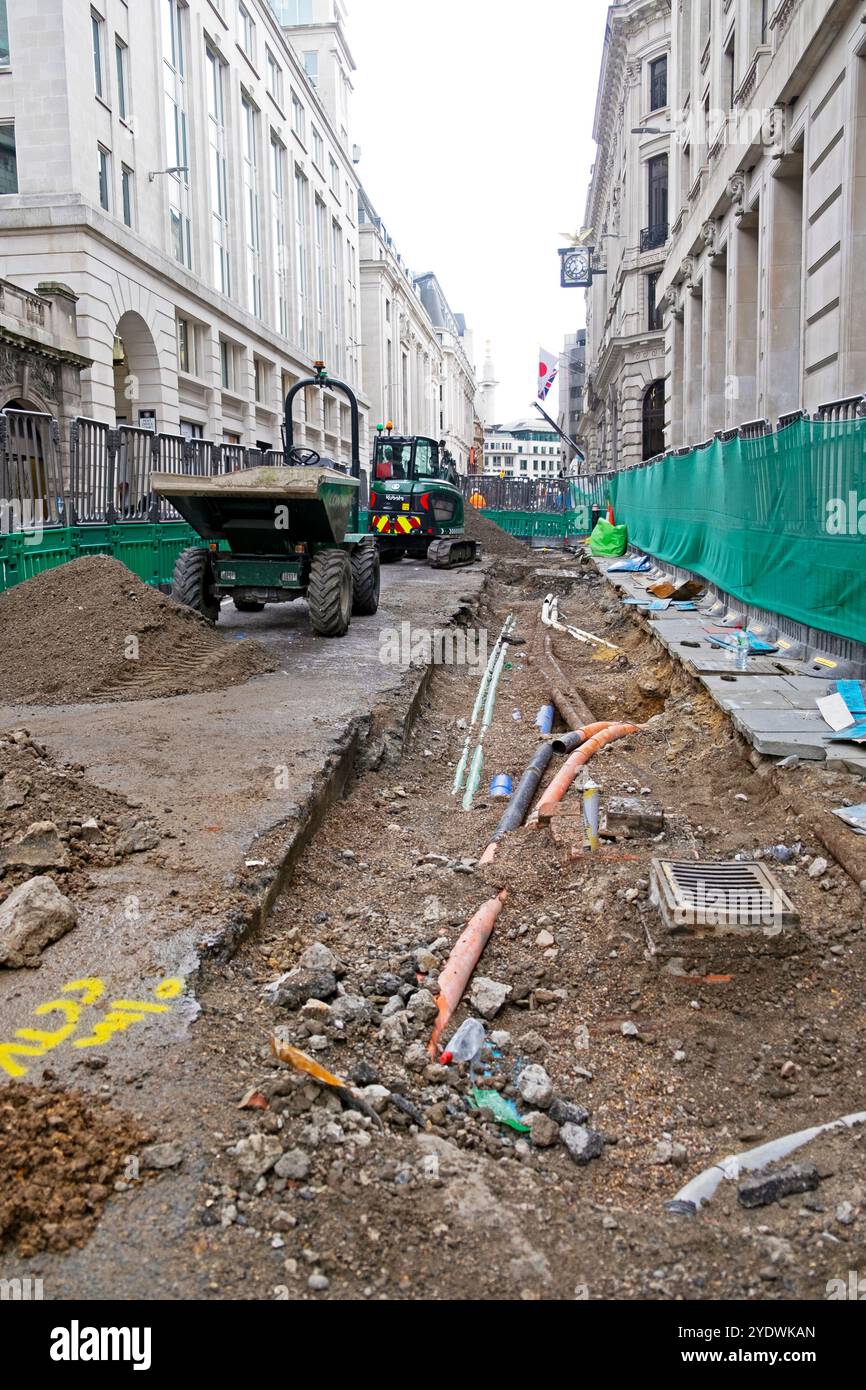 Orange grüne schwarze Versorgungsleitungen unter Straßenbelag in Stadtinfrastruktur London England Großbritannien Großbritannien Oktober 2024 KATHY DEWITT Stockfoto