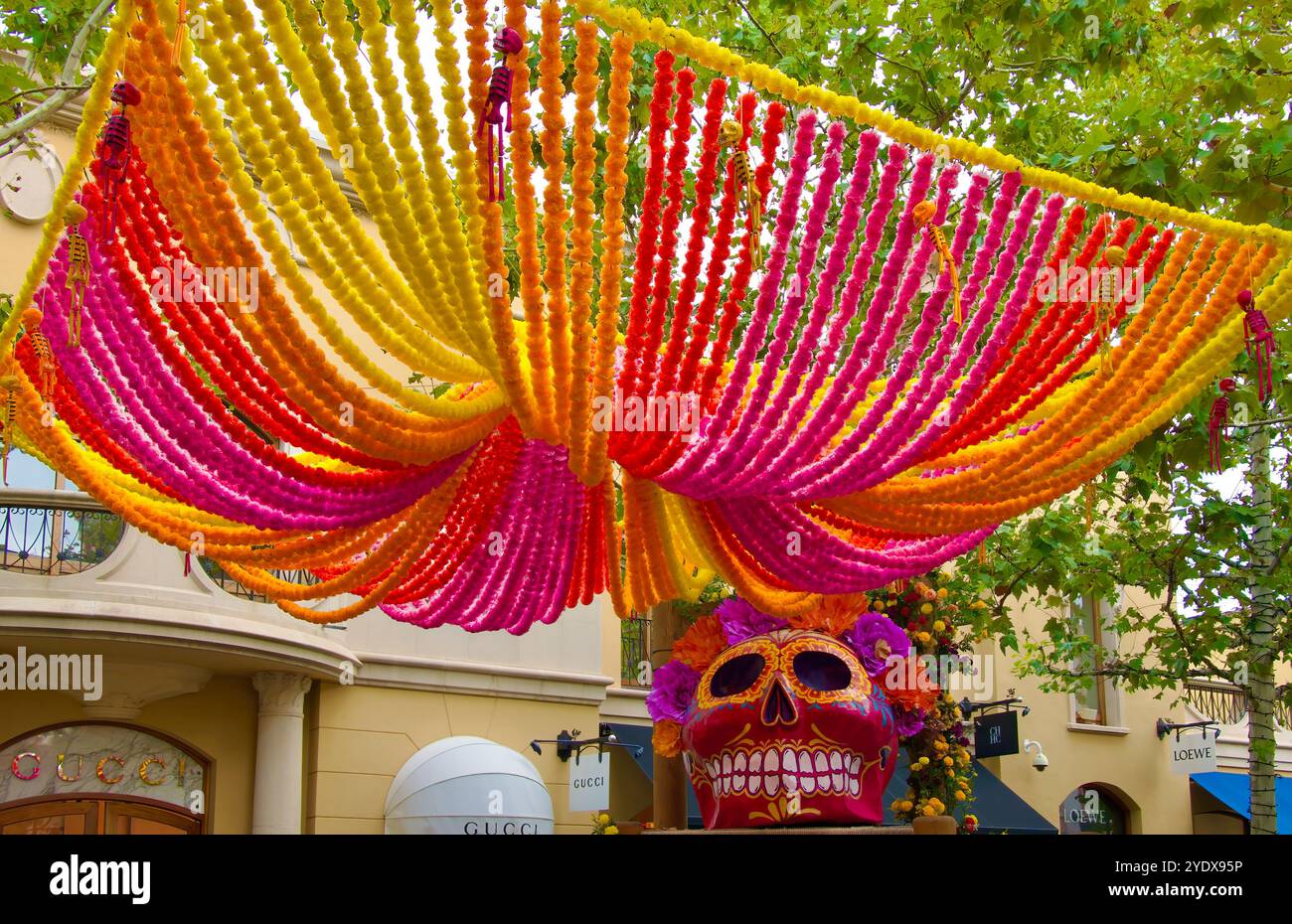 Riesiger, aus Pappe mâché bemalter Schädel auf einem riesigen Stuhl für Halloween oder Day of the Dead draußen im Las Rozas Village Outlet Einkaufszentrum Madrid Spanien Stockfoto