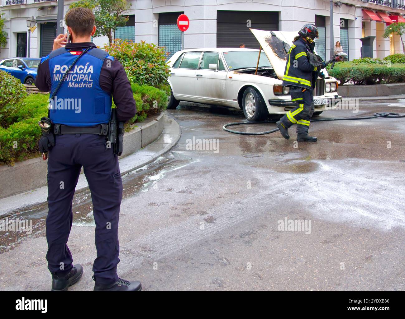 Der weiße 1980er Bentley brannte den Motorraum aus, die Motorhaube war offen und die Polizei und die Feuerwehr waren in einer Straße im Stadtzentrum von Madrid, Spanien Stockfoto