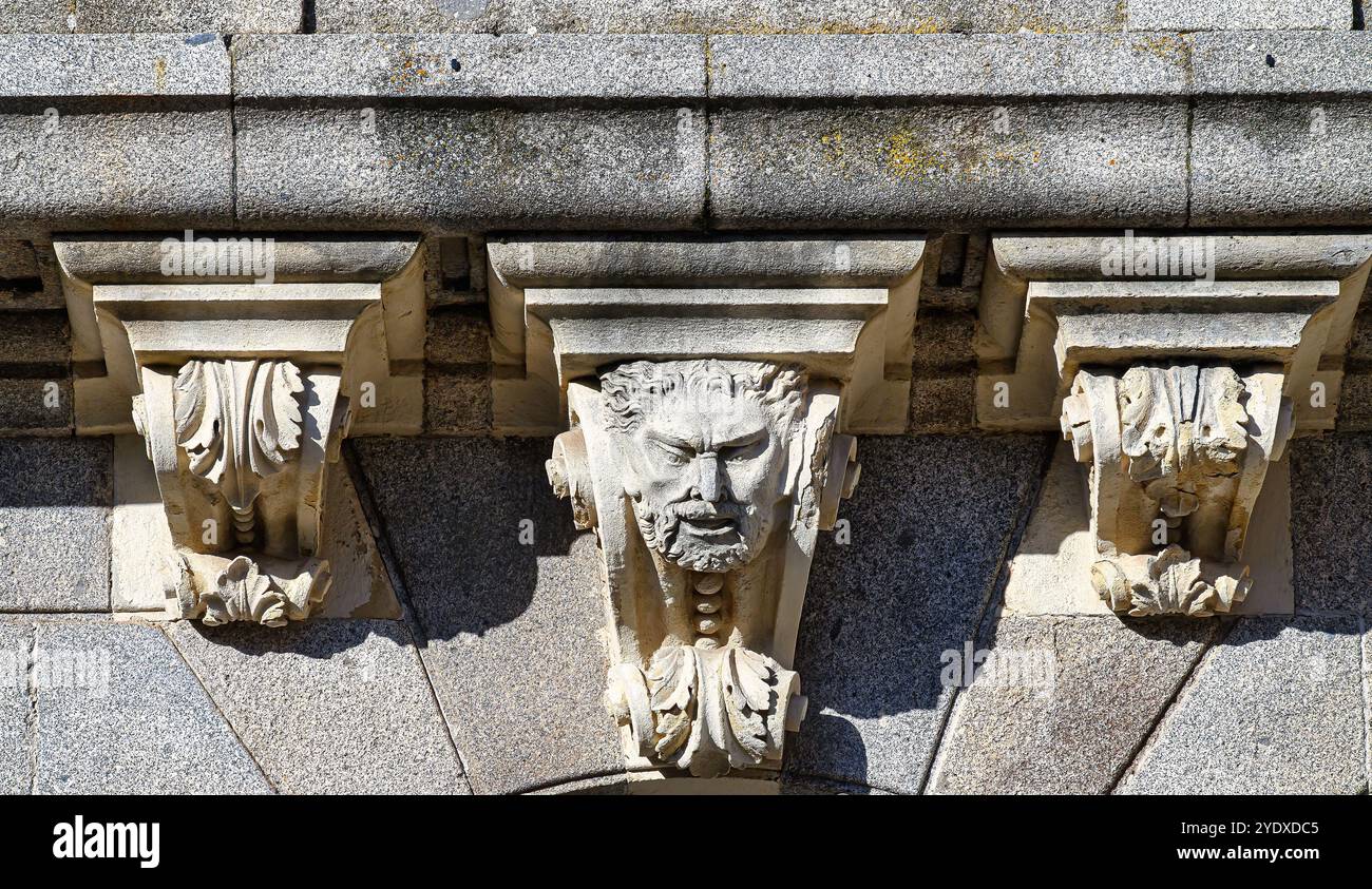 Avila, Spanien - 11. Februar 2023: Stützkonstruktion aus Stein mit dekorativen Elementen an der Fassade eines alten Steingebäudes. Stockfoto