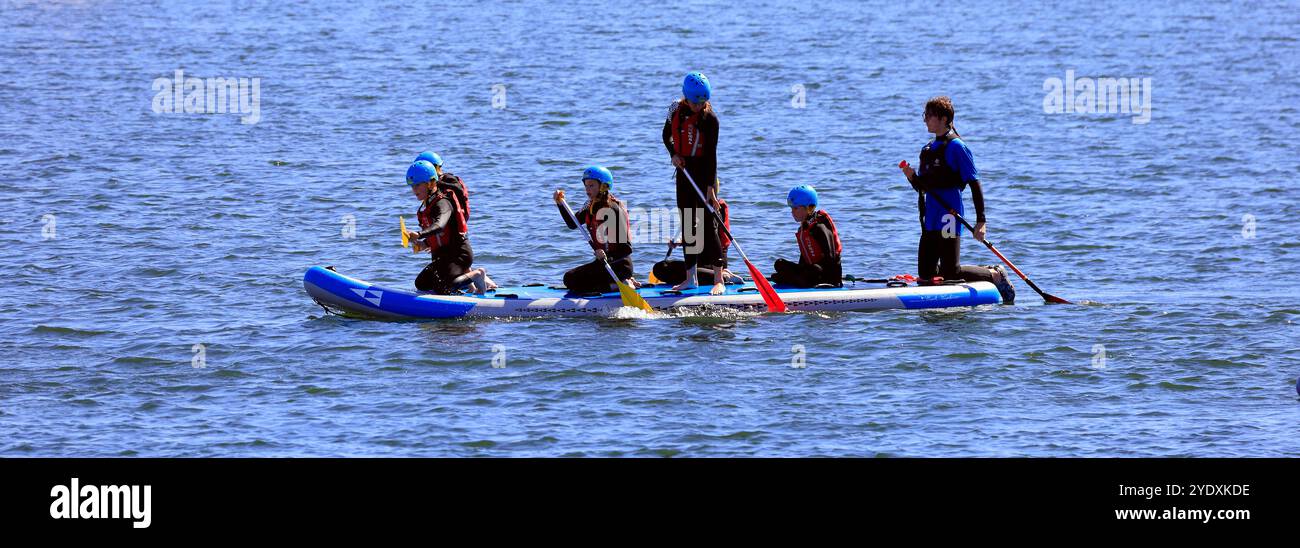 Paddelboardunterricht für Jugendliche in Sicherheitsausrüstung auf einem großen Paddelbrett, Lisvane & Llanishen Stauseen, Sommer 2024 Stockfoto