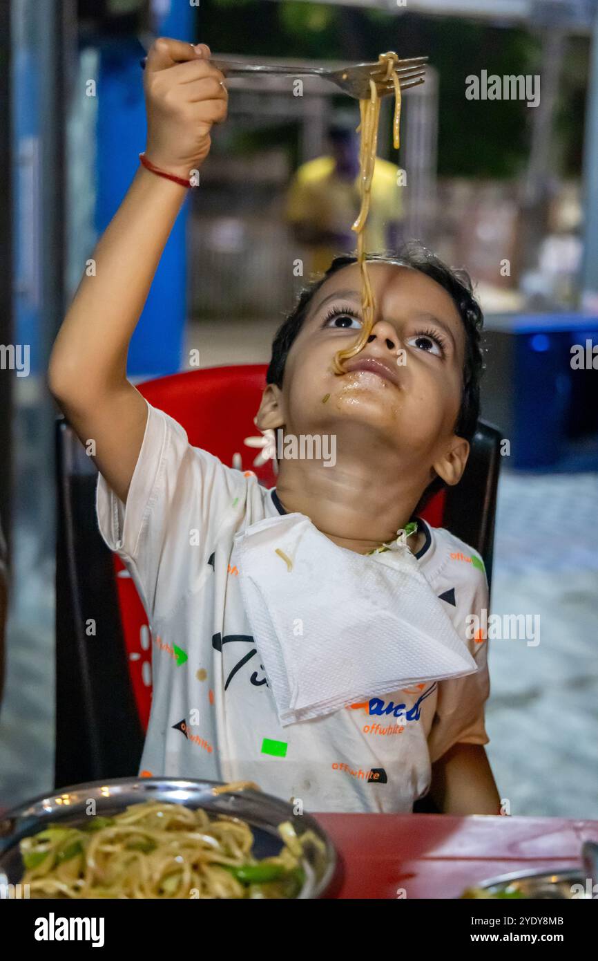 Ein Kind isst Hakka-Nudeln in der Nacht aus dem flachen Winkel Stockfoto