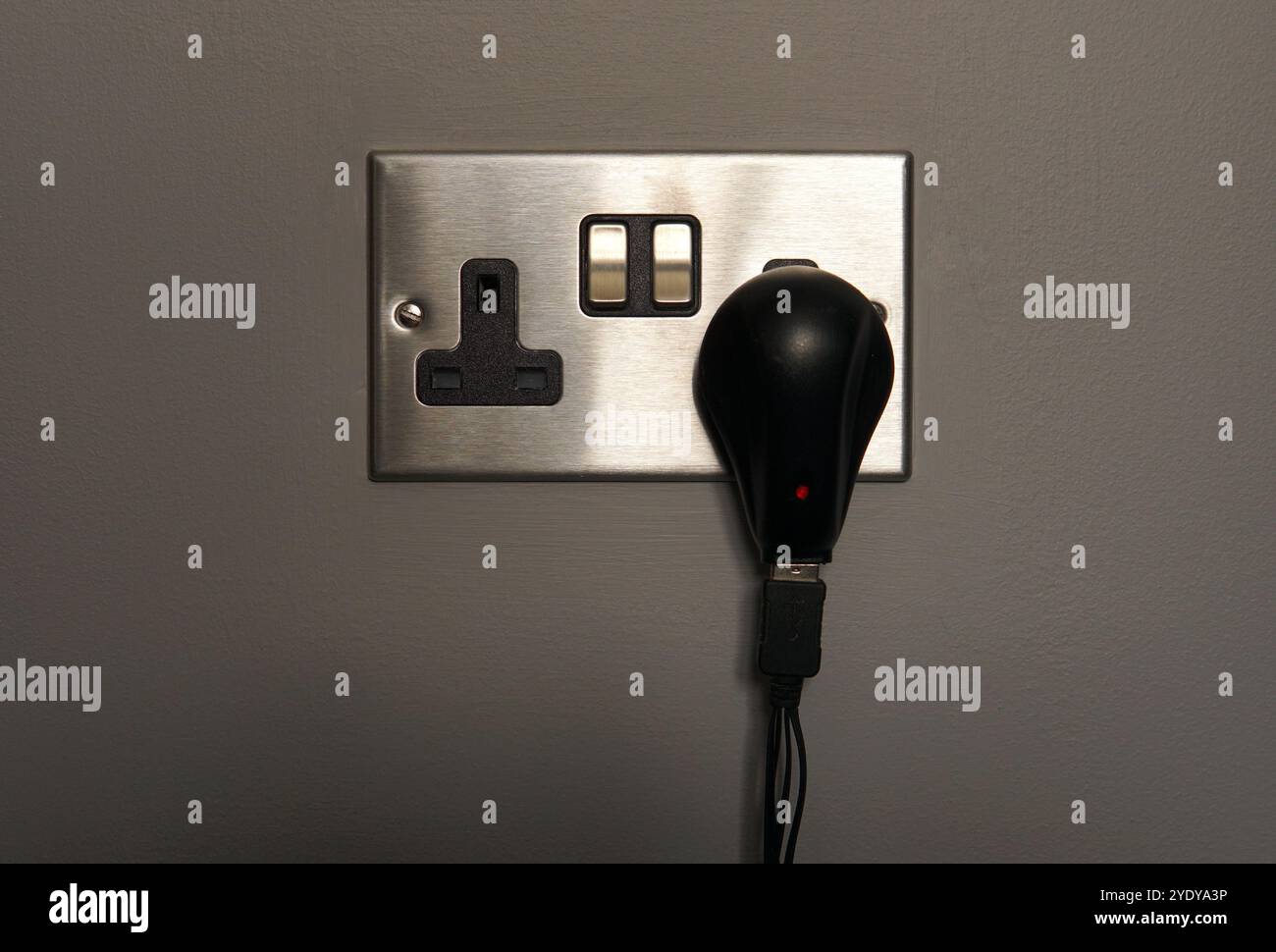 UK-Wandsteckdose (gebürstetes Silber) mit Schalter und 5-V-Netzteil Stockfoto