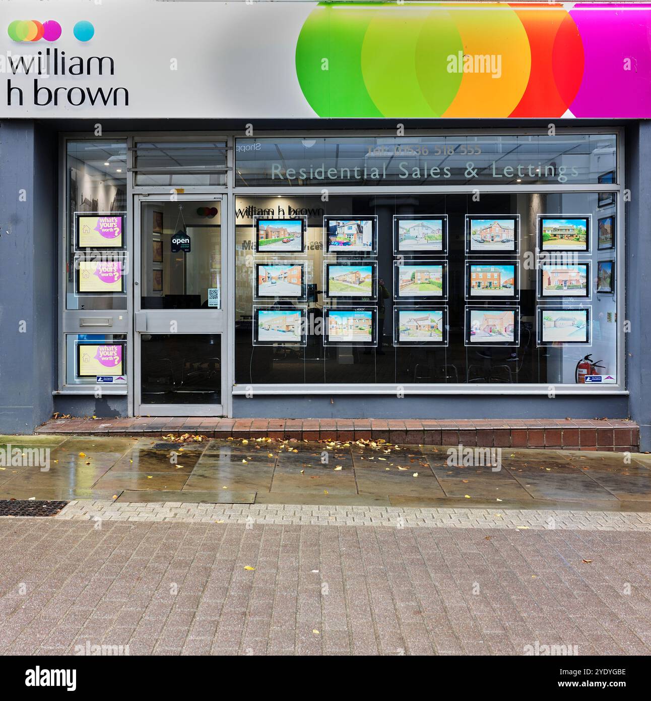 William H Brown, Immobilienmakler, im Stadtzentrum von Kettering, England, an einem nassen Tag. Stockfoto